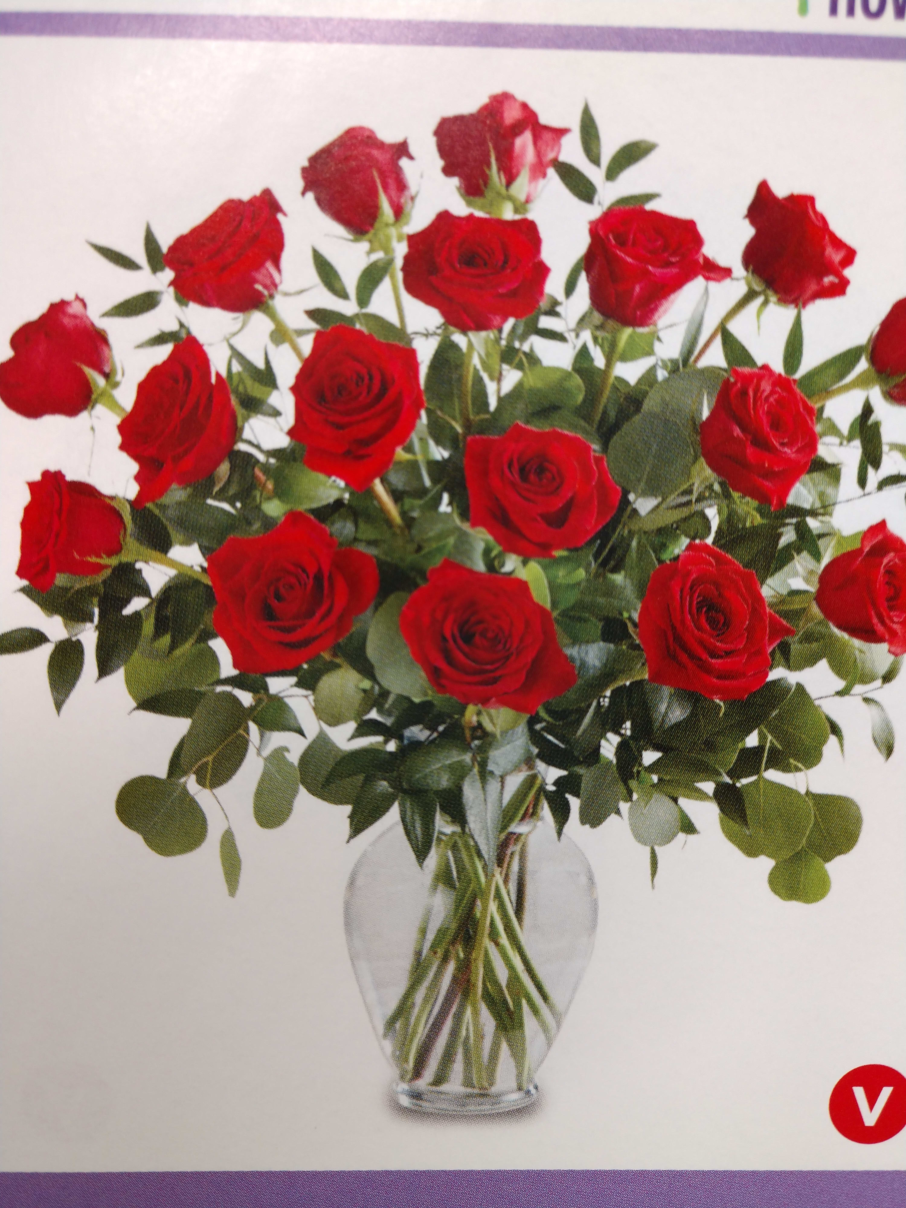 Red roses arranged in a clear glass vase