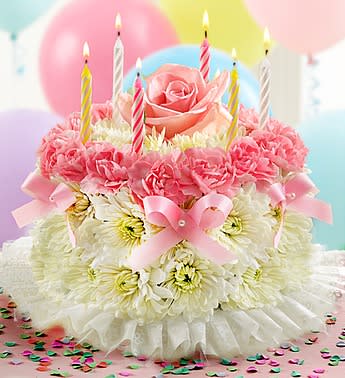 Birthday Flower Cake Pastel - Product ID: 1991  Our signature floral birthday cake may look good enough to eat, but it's actually crafted from fresh pastel flowers such as mini carnations and poms.  a set of candles where available, and with proper care, can last days after the celebration is complete. Fresh, hand-crafted cake-shaped arrangement of pastel mini carnations and cushion poms in floral foam, topped with a single paste lcandle Arrangement measures approximately 7"H x 8"D Our florists hand-design each arrangement, so colors, varieties, and container may vary due to local availability
