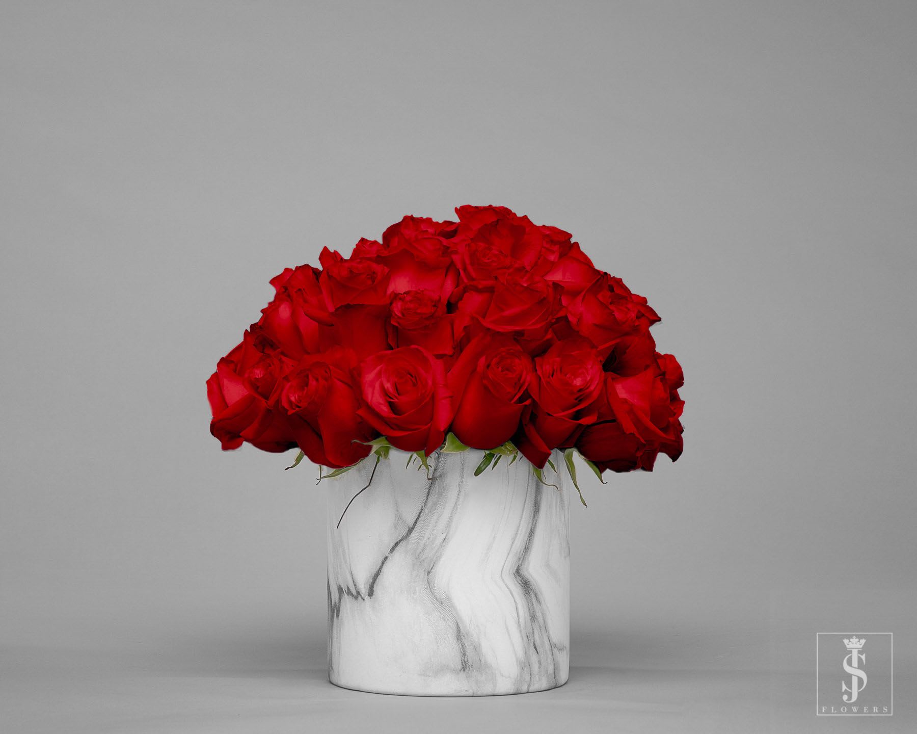 Red roses arranged in a white marble vase