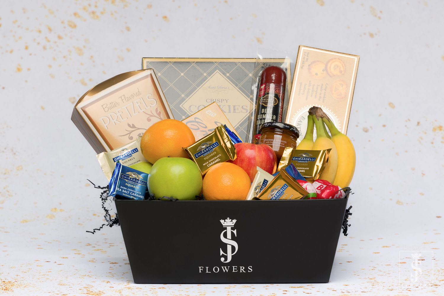 Gift basket with fruit, chocolates, cookies, and a bottle in a black box