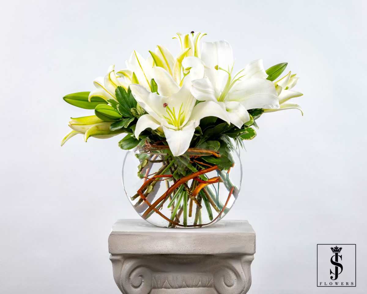 White lilies arranged in a clear glass vase