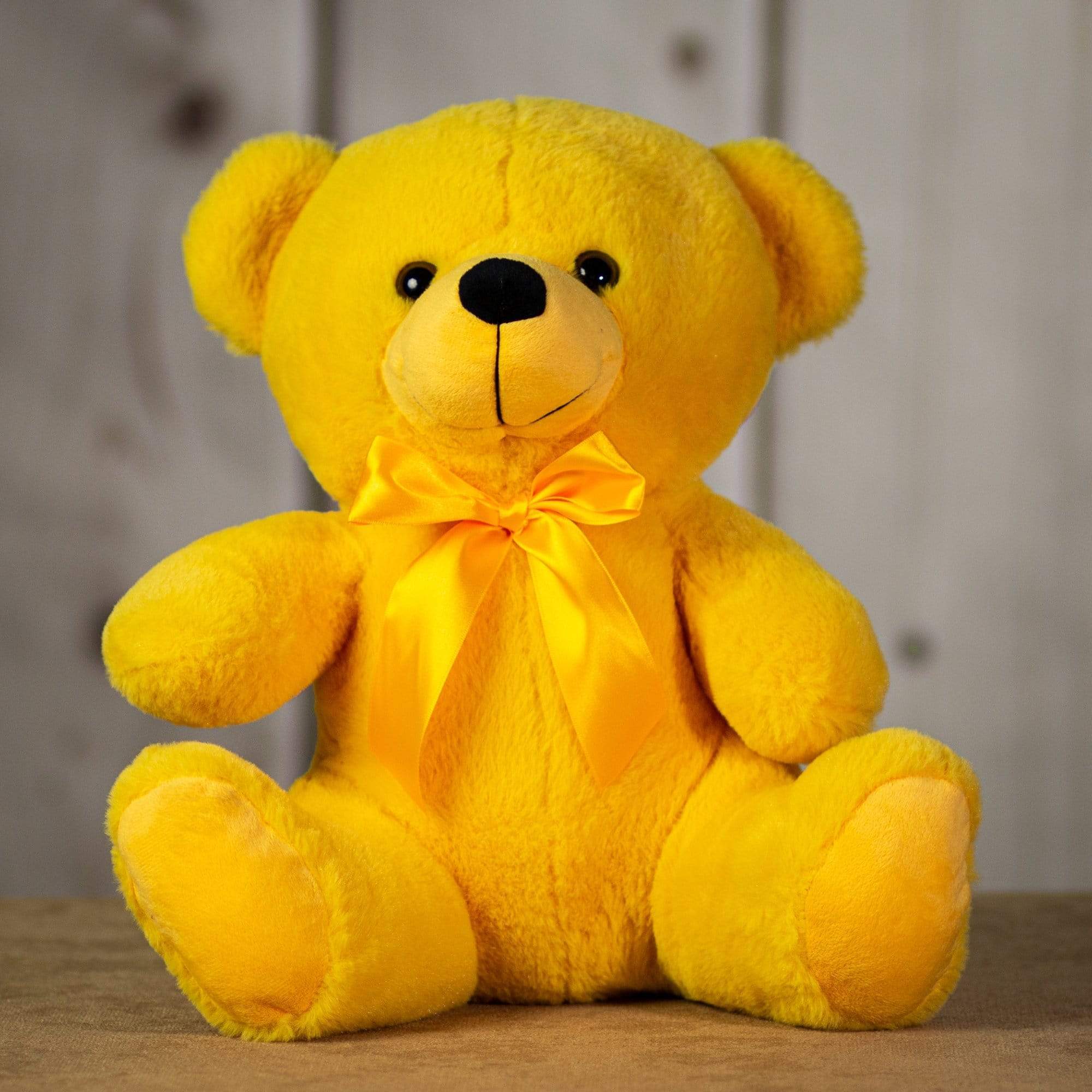 Yellow teddy bear with a satin bow