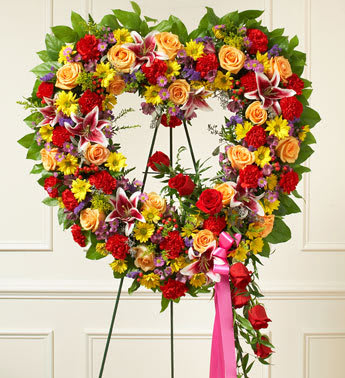 Always Remember Floral Heart Tribute - Bright (Easel Stand) - When words aren't enough to express your sympathy and love, this open heart standing spray of bright blooms conveys your condolences beautifully. Crafted of beautiful red and peach roses, lilies, carnations, alstroemeria, daisy poms and more Accented by salal, seeded eucalyptus and more Sent directly to the funeral home by family and friends Our florists use only the freshest flowers available so colors and assortment may vary Measures approximately 34"H x 32"L without easel