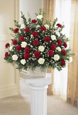 Large red and white floral spray on a pedestal stand