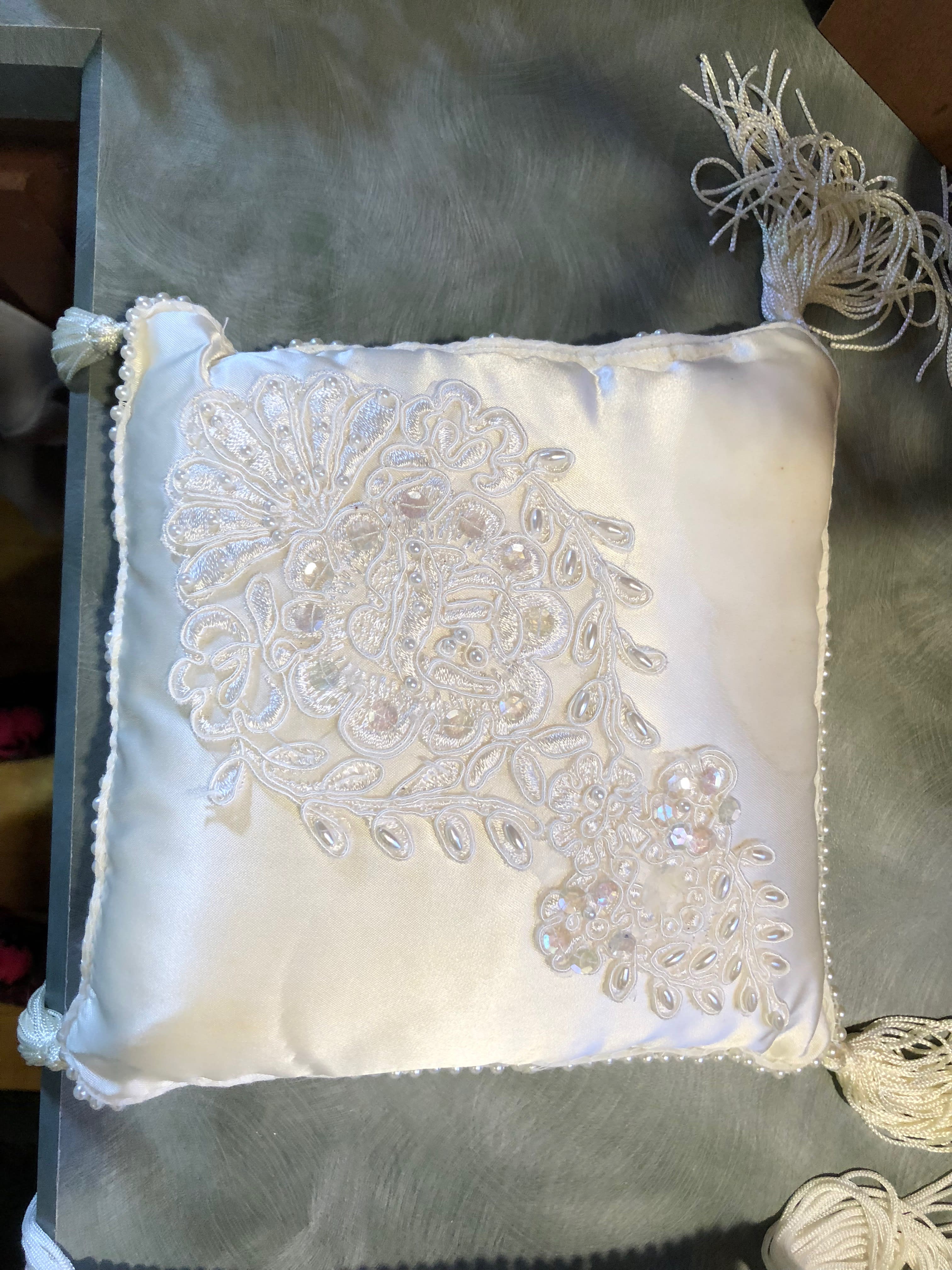 White satin decorative pillow with beaded floral embroidery and tassels
