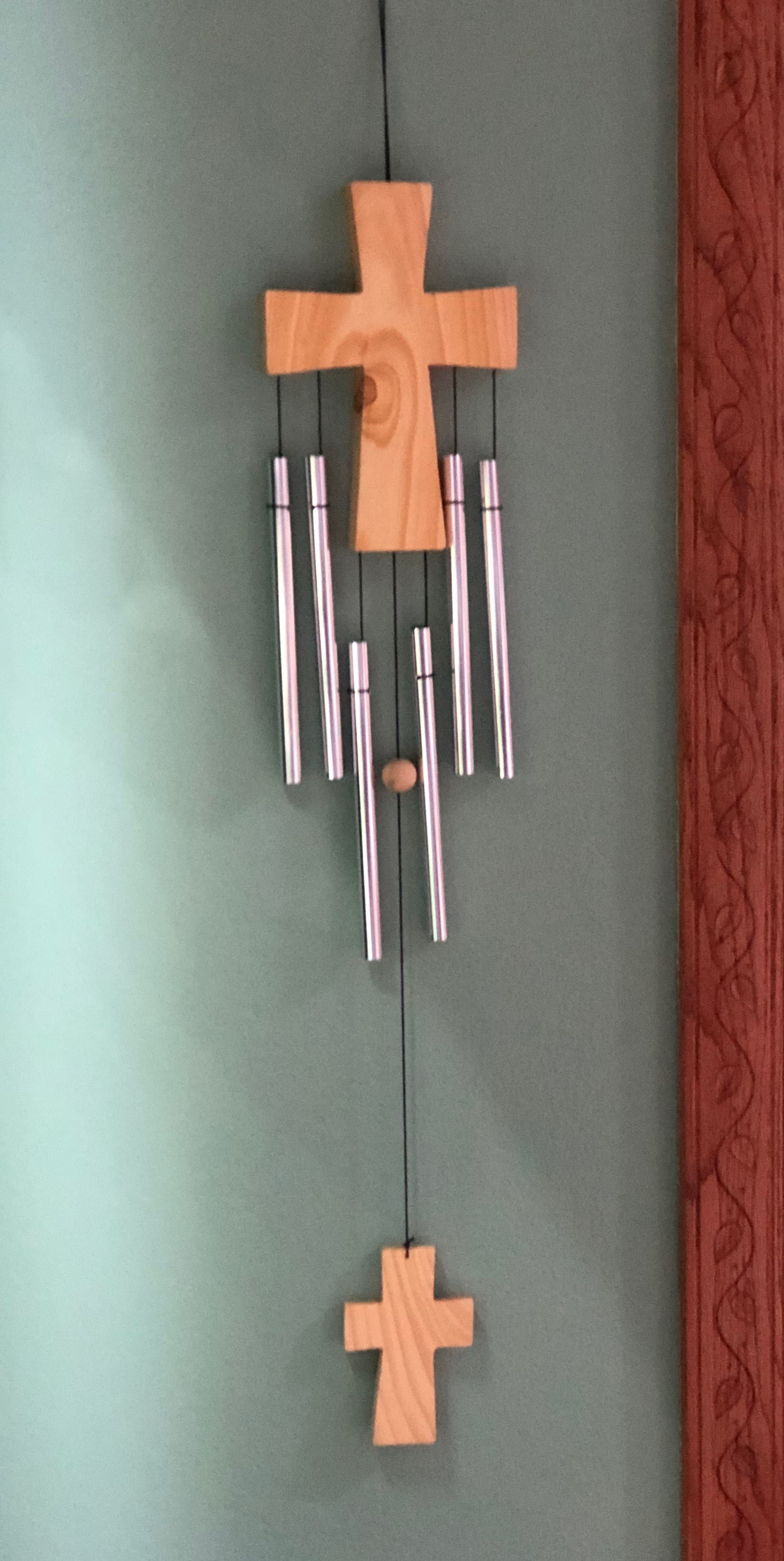 Wooden cross wall hanging with silver wind chimes