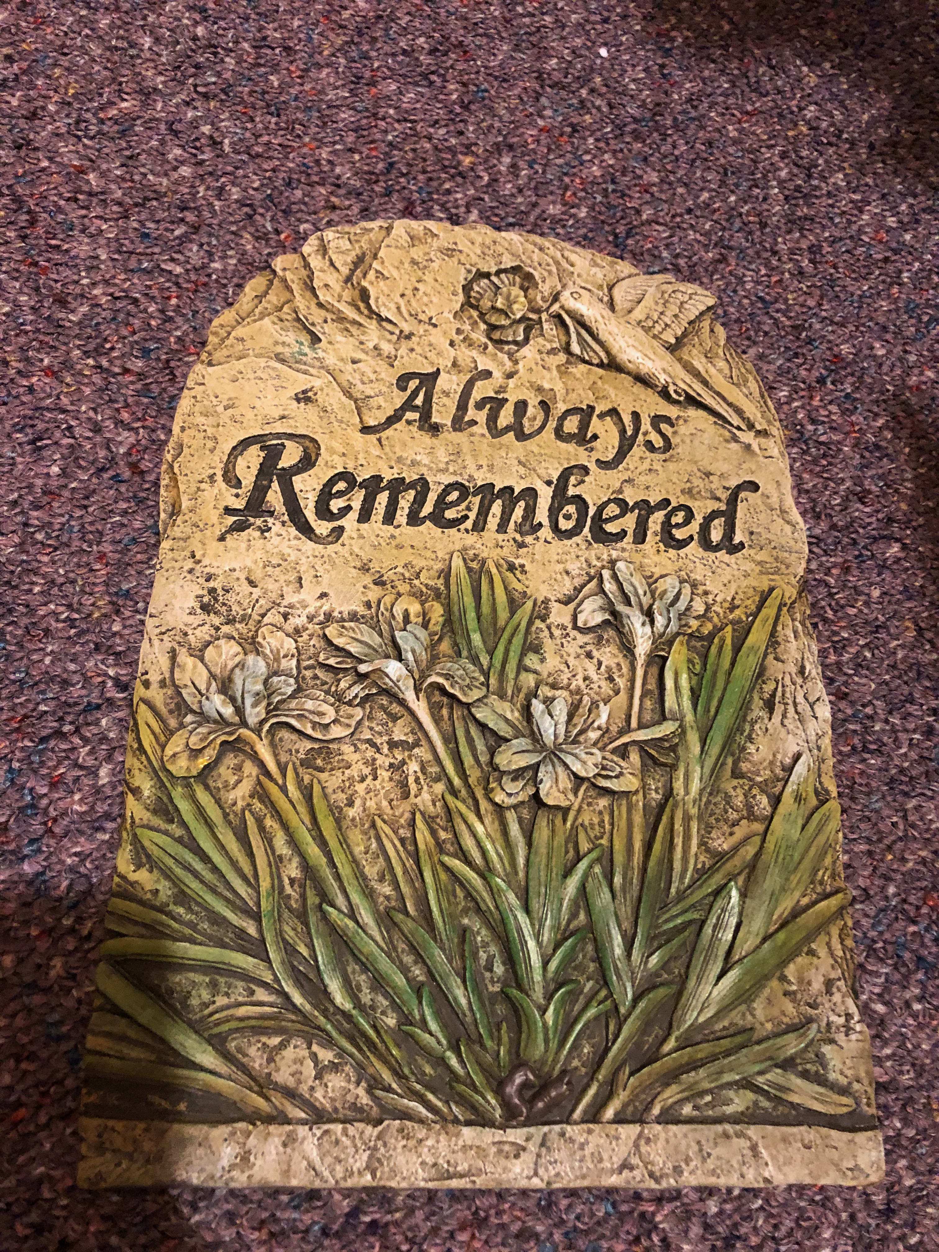 Decorative stone plaque with the words Always Remembered and carved flowers