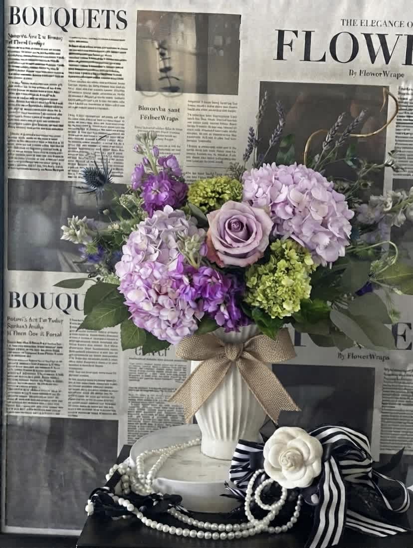 Lavender and purple bouquet in a white vase with a burlap bow
