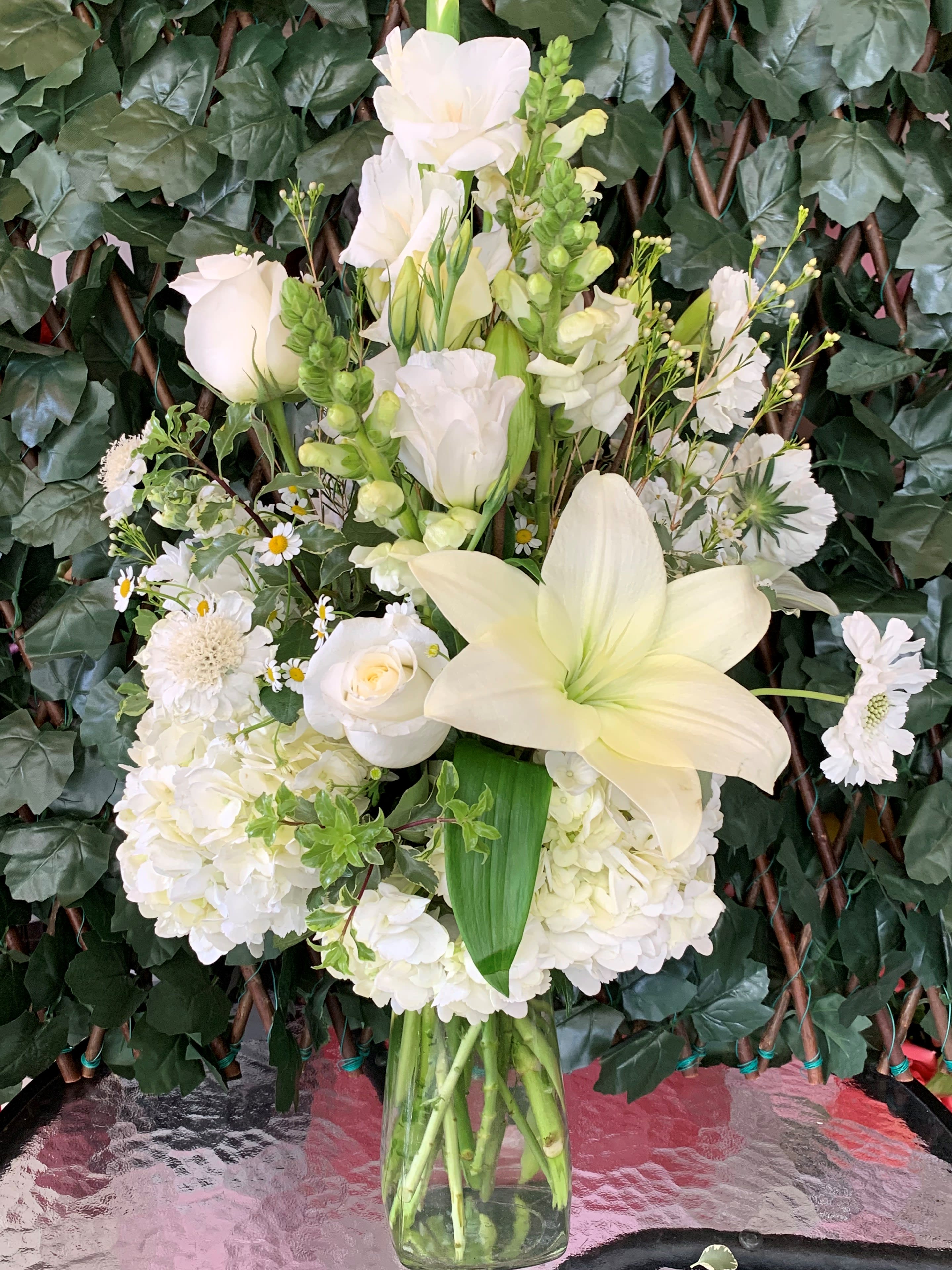 Snow Bliss  - Floral glass vase arrangement with roses, dragon snaps, hydrangeas, gladiolas and foliage