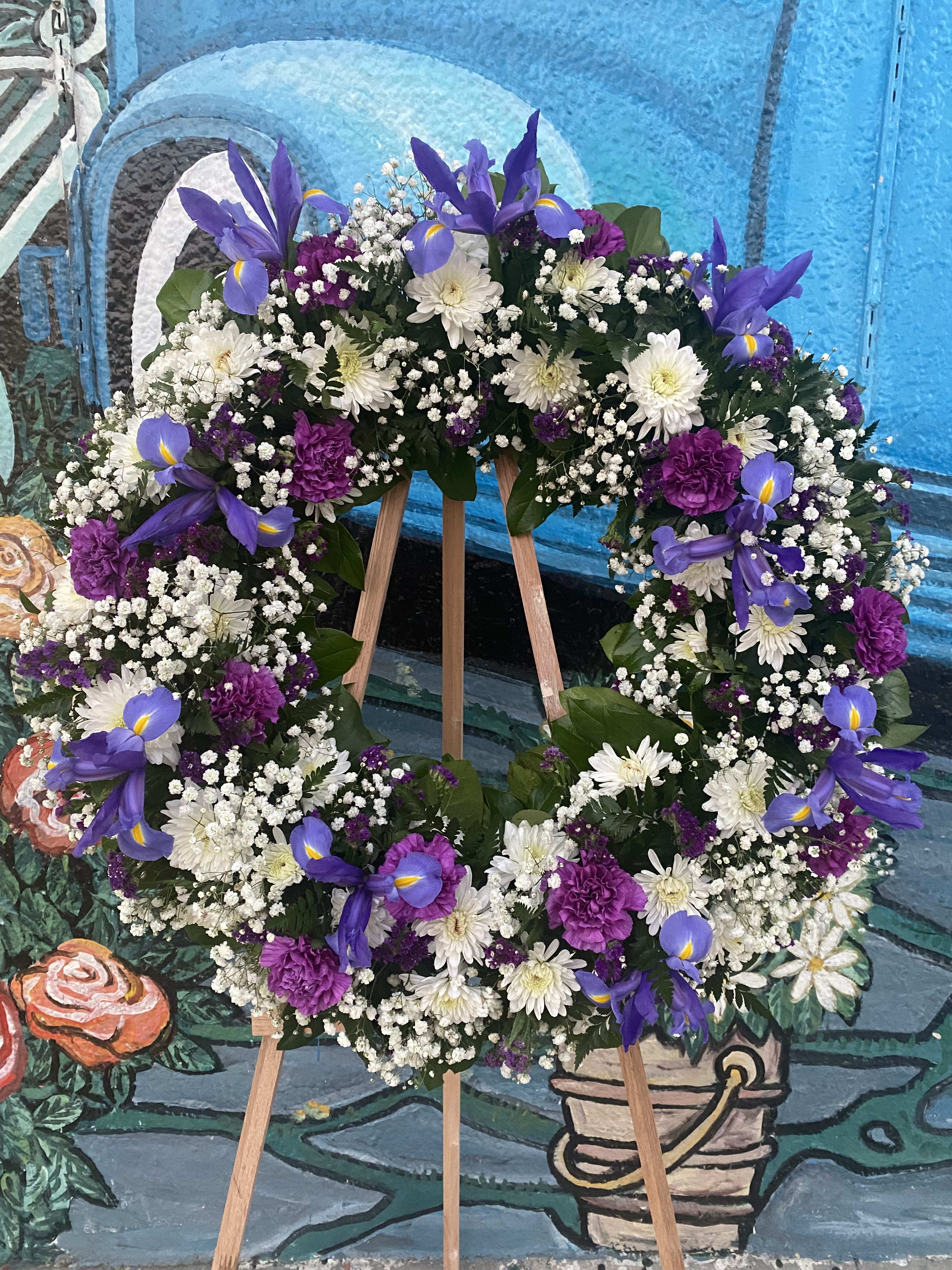 Purple and white floral wreath on a wooden easel