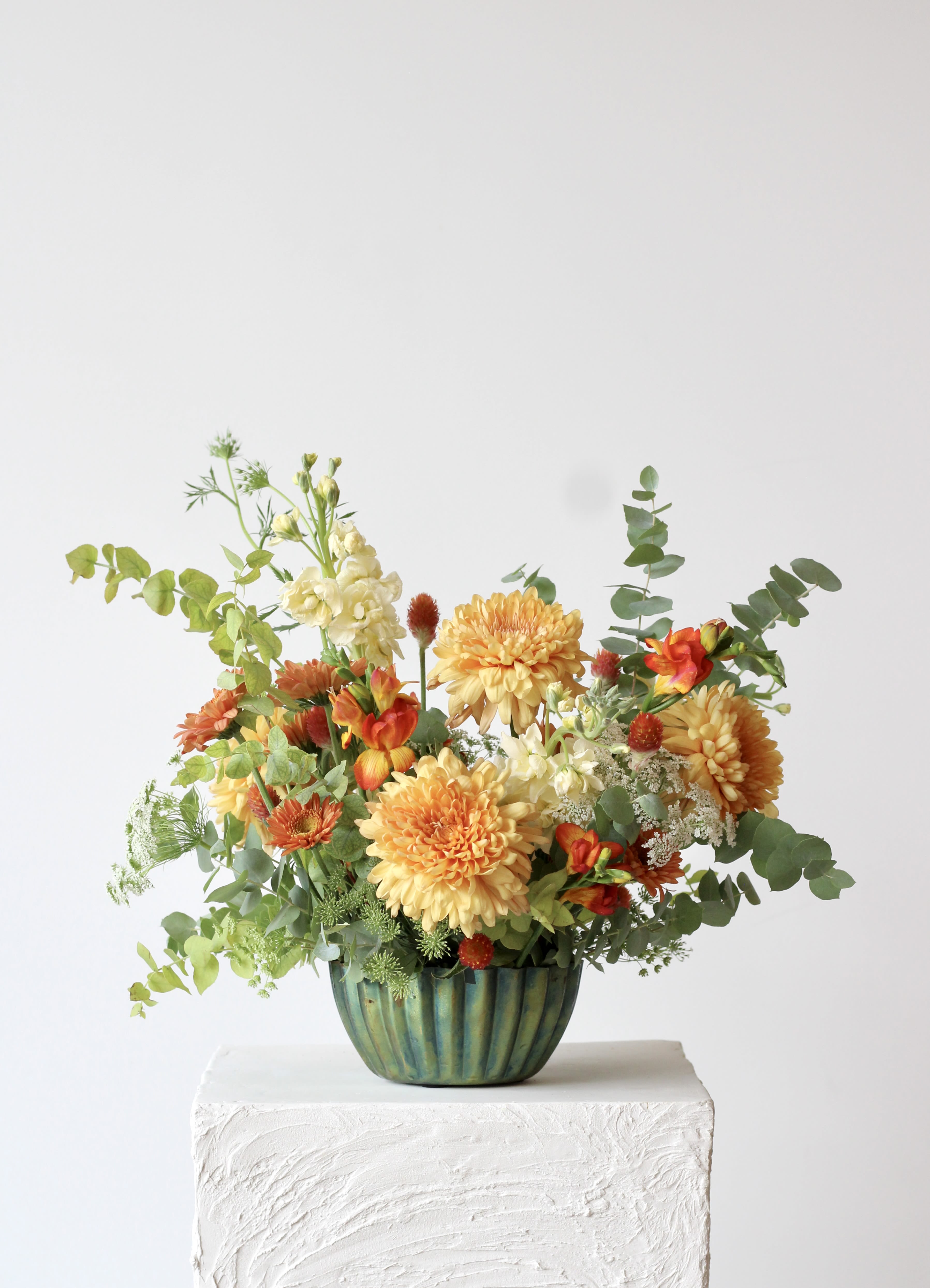Summer Oasis - Meet “Spring Oasis,” a vibrant floral arrangement blending gold, fiery orange, and fresh greens in a shimmering blue green iridescent container. With its unexpected color palette, it offers a refreshing twist on seasonal décor. Perfect for brightening your home or gifting to someone special.  Delivery Policy: At Middlemist, we aim to make every delivery seamless and delightful. It is the sender’s responsibility to ensure the recipient is available to accept delivery between 3–5pm on the scheduled date and that the delivery address is accurate. We will send a text notification to the recipient on the day of delivery. If no one is available to receive the order, it will be returned to the shop and may be picked up or redelivered for an additional delivery fee. If a recipient requests the order be left unattended, we cannot guarantee the condition of the flowers or plants, and no refunds will be issued once an order is left outside.
