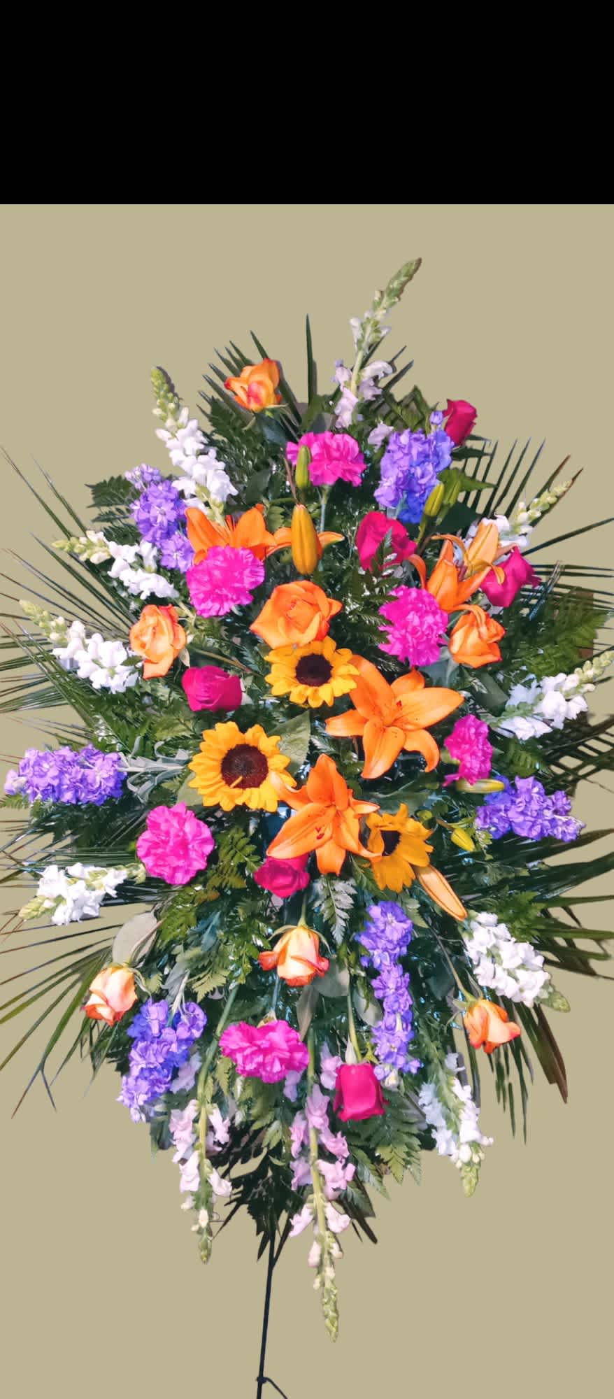 Large standing spray with orange lilies, roses, and purple flowers