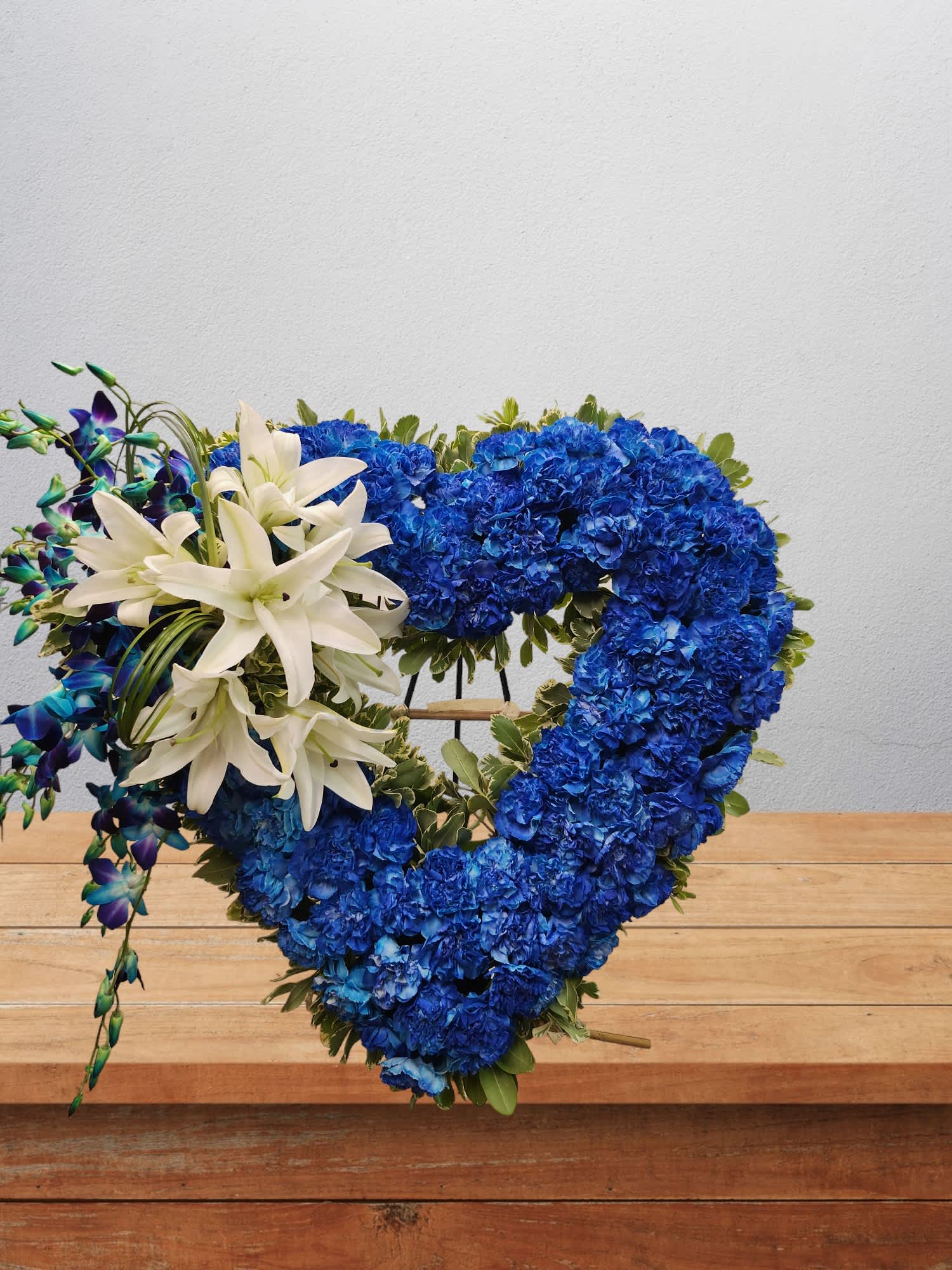 Blue floral heart wreath with white lilies and purple orchids