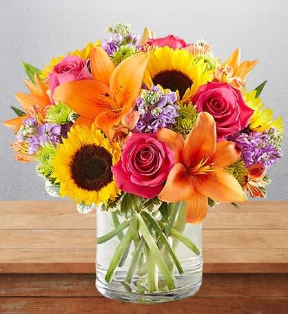 Summer surprise - Embrace the beauty of nature with our cylinder glass vase filled with a delightful mix of flowers, highlighted by cheerful sunflowers. This vibrant arrangement is a perfect expression of joy and warmth, ideal for any occasion. Approximately 12wx 14h