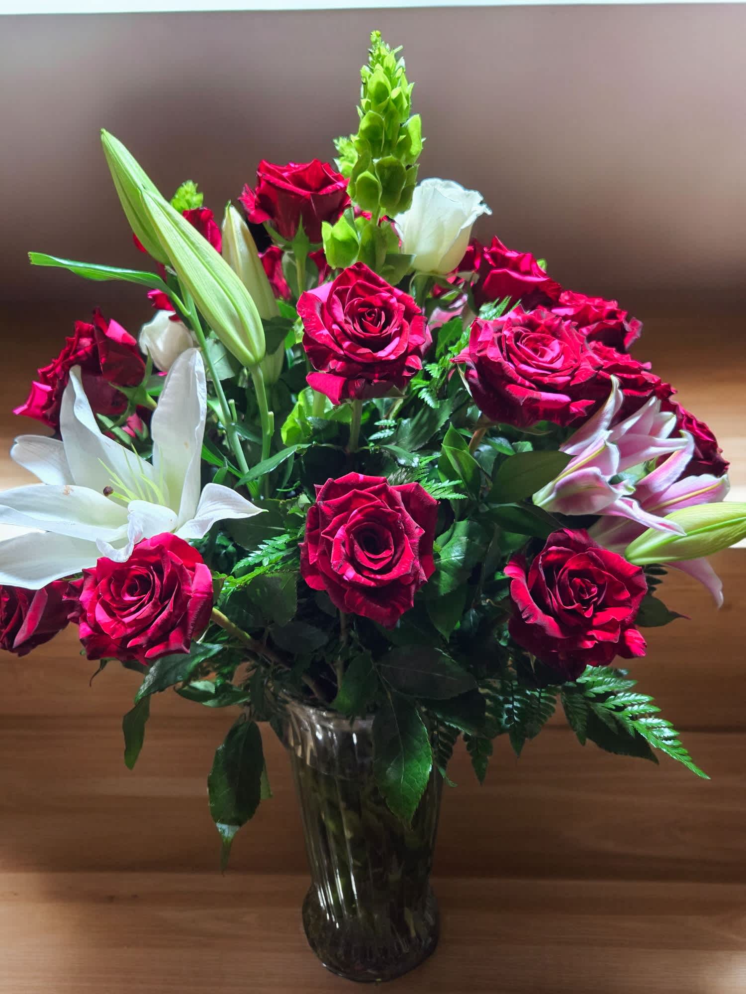 Bouquet of red roses and white lilies in a glass vase