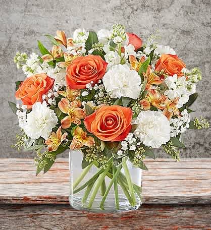 Bouquet of orange and white flowers in a clear glass vase