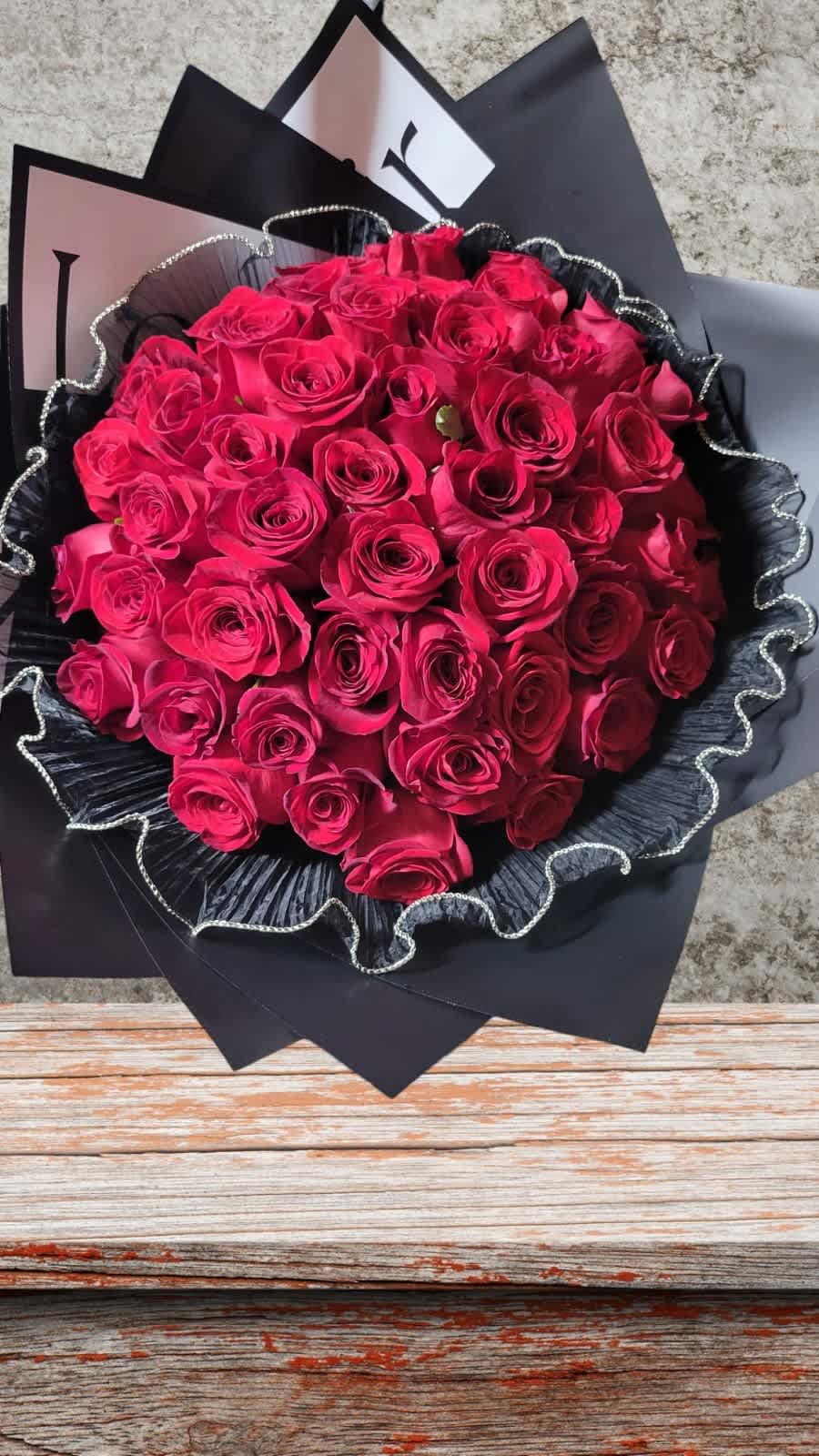 Bouquet of hot pink roses wrapped in black paper