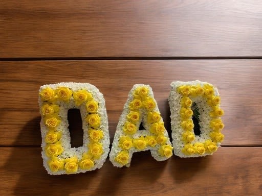 Yellow and white floral letters spelling DAD