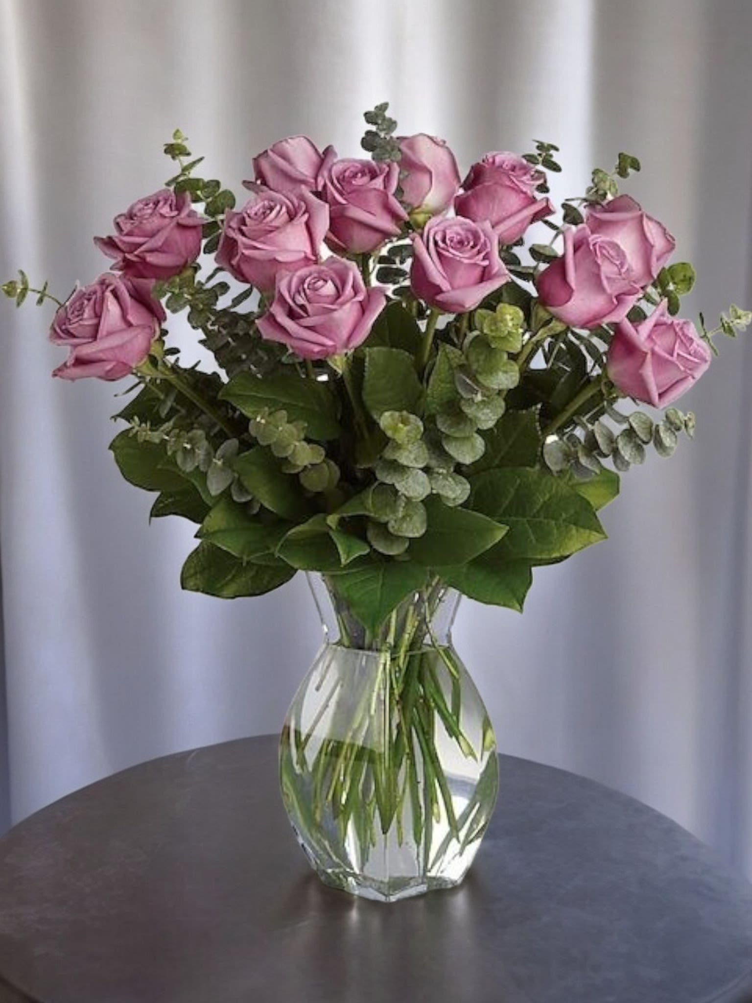 Pink roses arranged in a clear glass vase