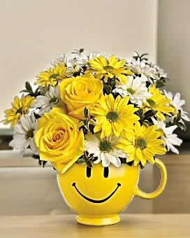 Yellow smiley-face mug filled with yellow and white flowers