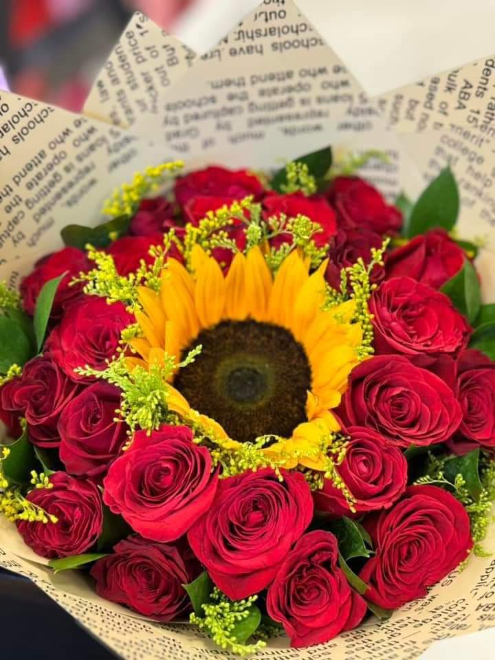 Bouquet of red roses with a sunflower center