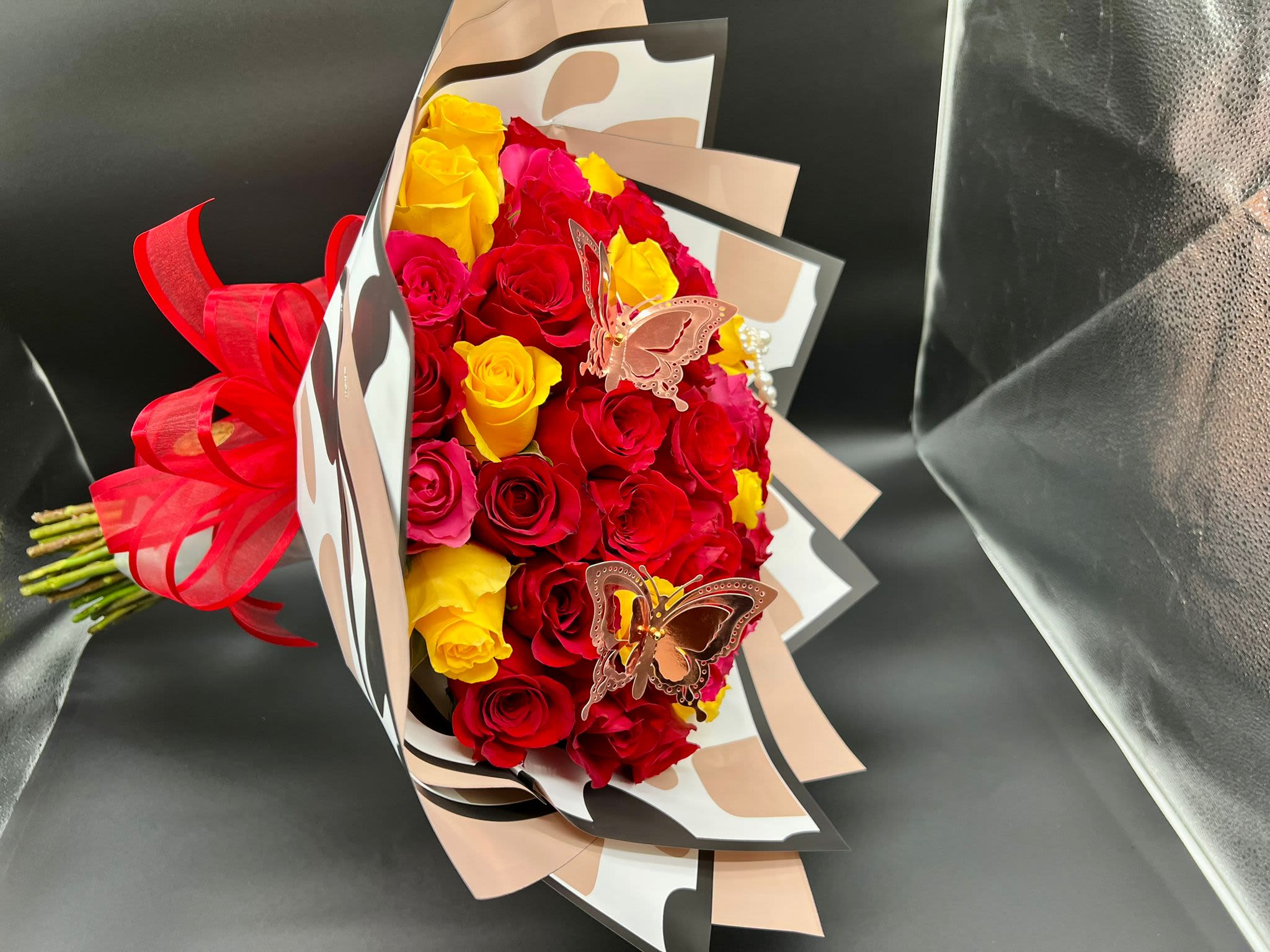 Bouquet of red and yellow roses with butterfly decorations