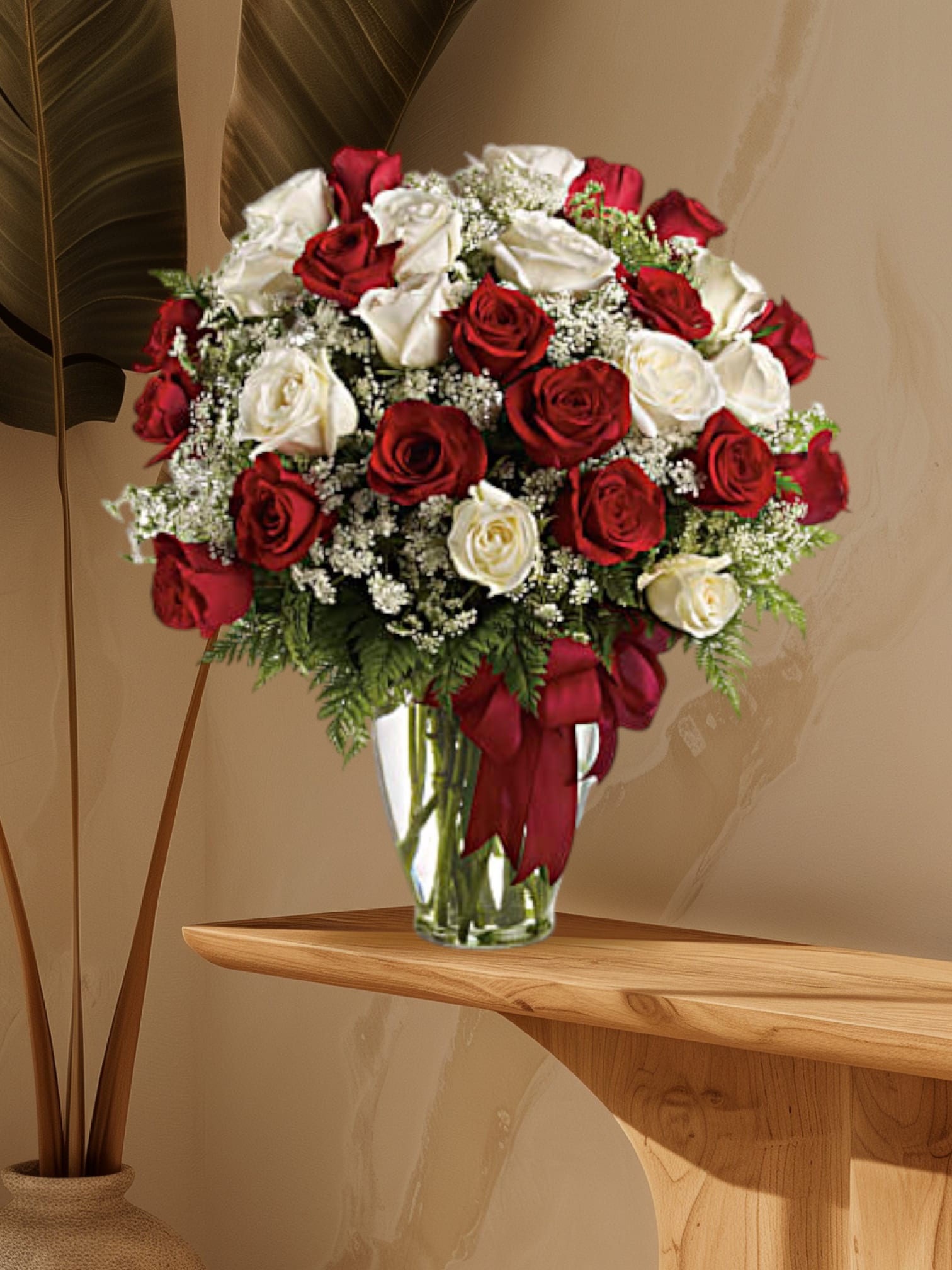 Red and white roses arranged in a clear glass vase