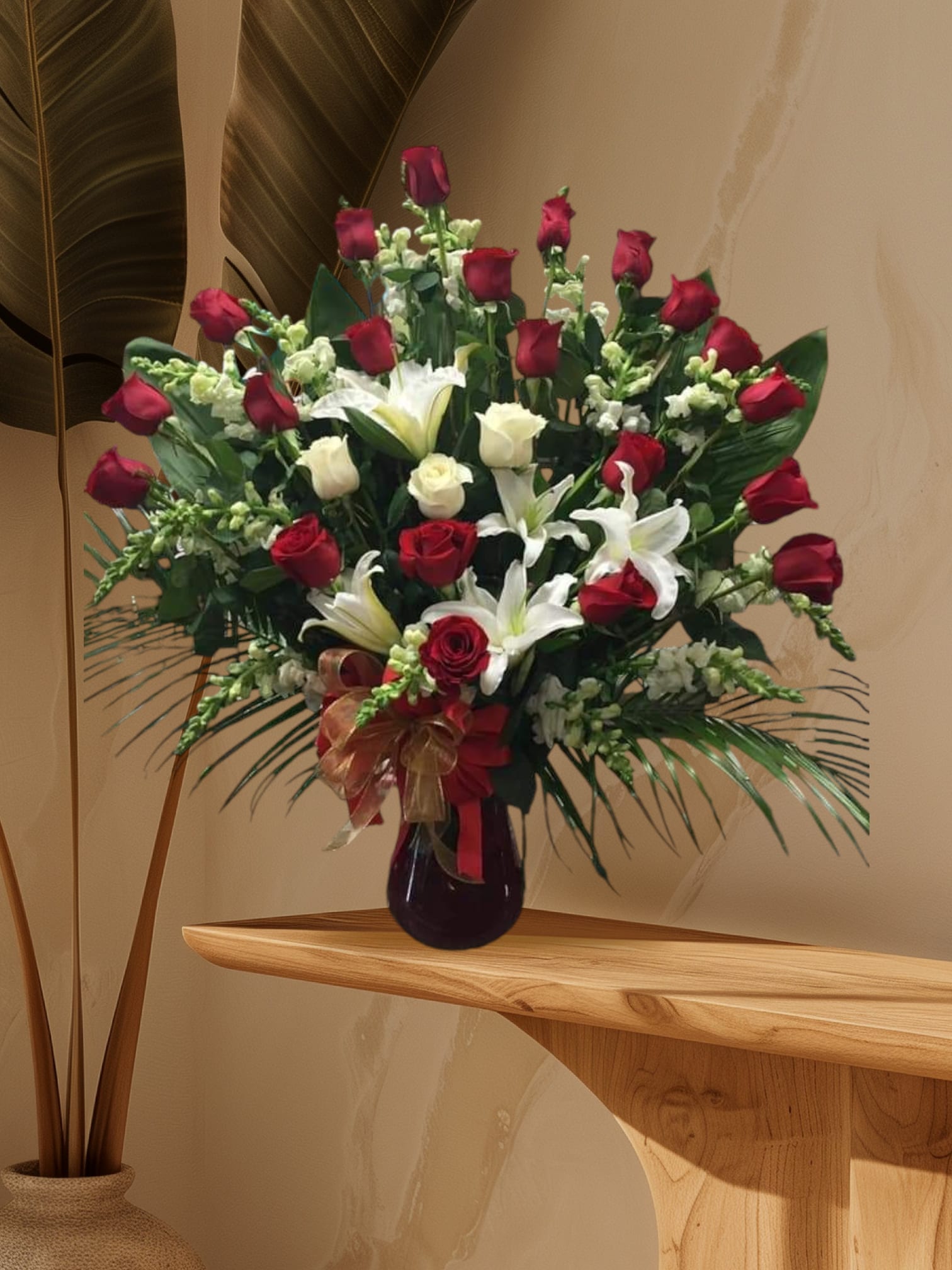Tall bouquet of red and white roses with lilies in a dark vase