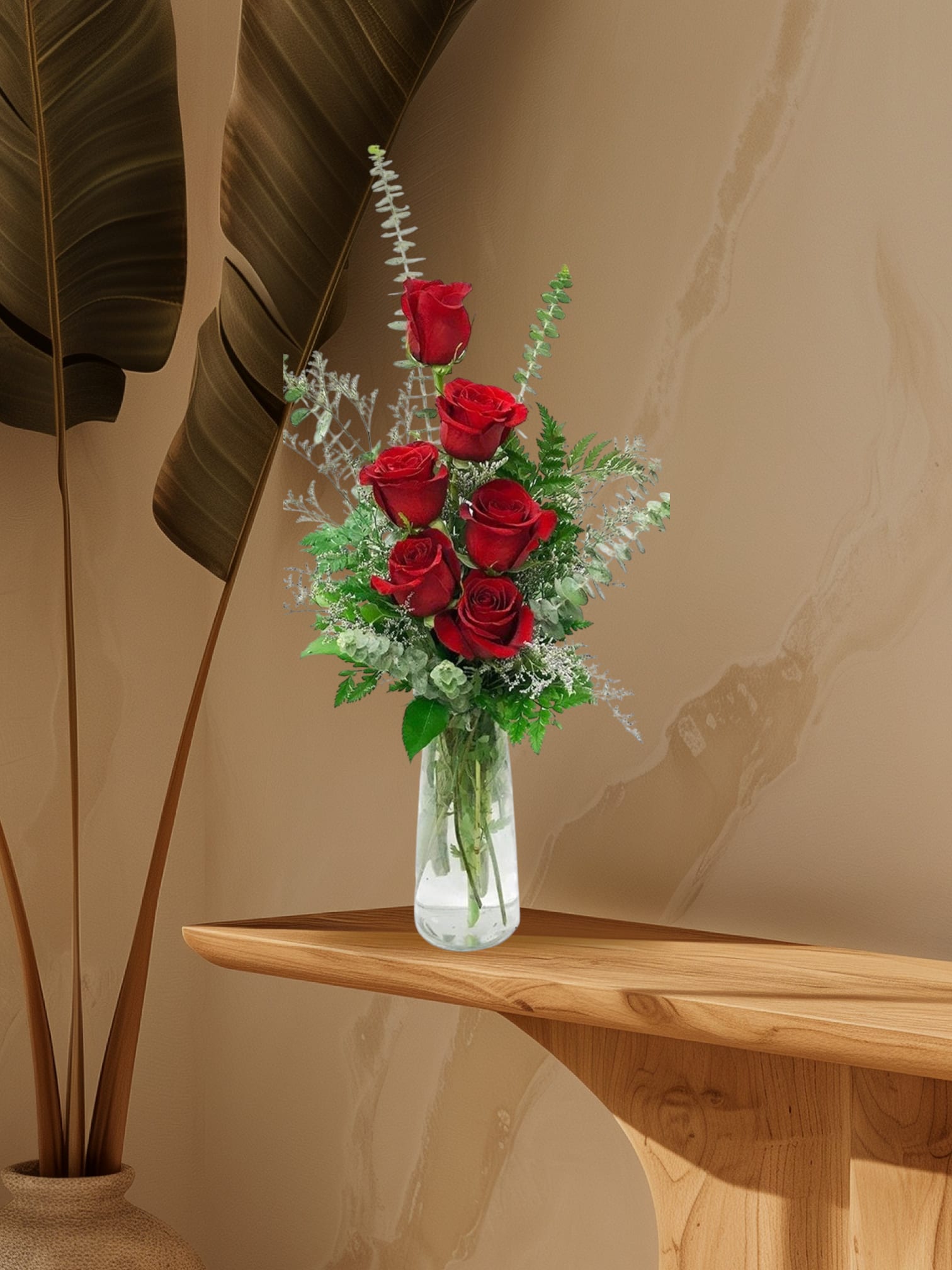 Red roses arranged in a clear glass vase