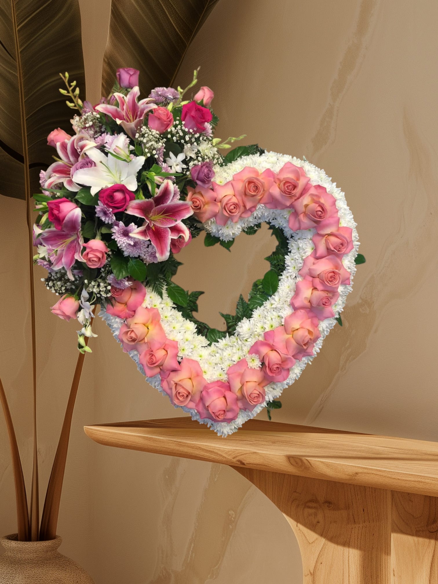 Heart-shaped floral wreath with pink roses and lilies