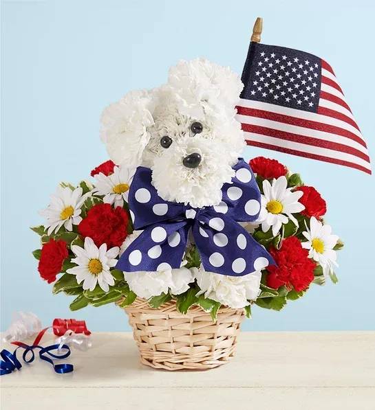 White dog-shaped floral arrangement in a basket with an American flag