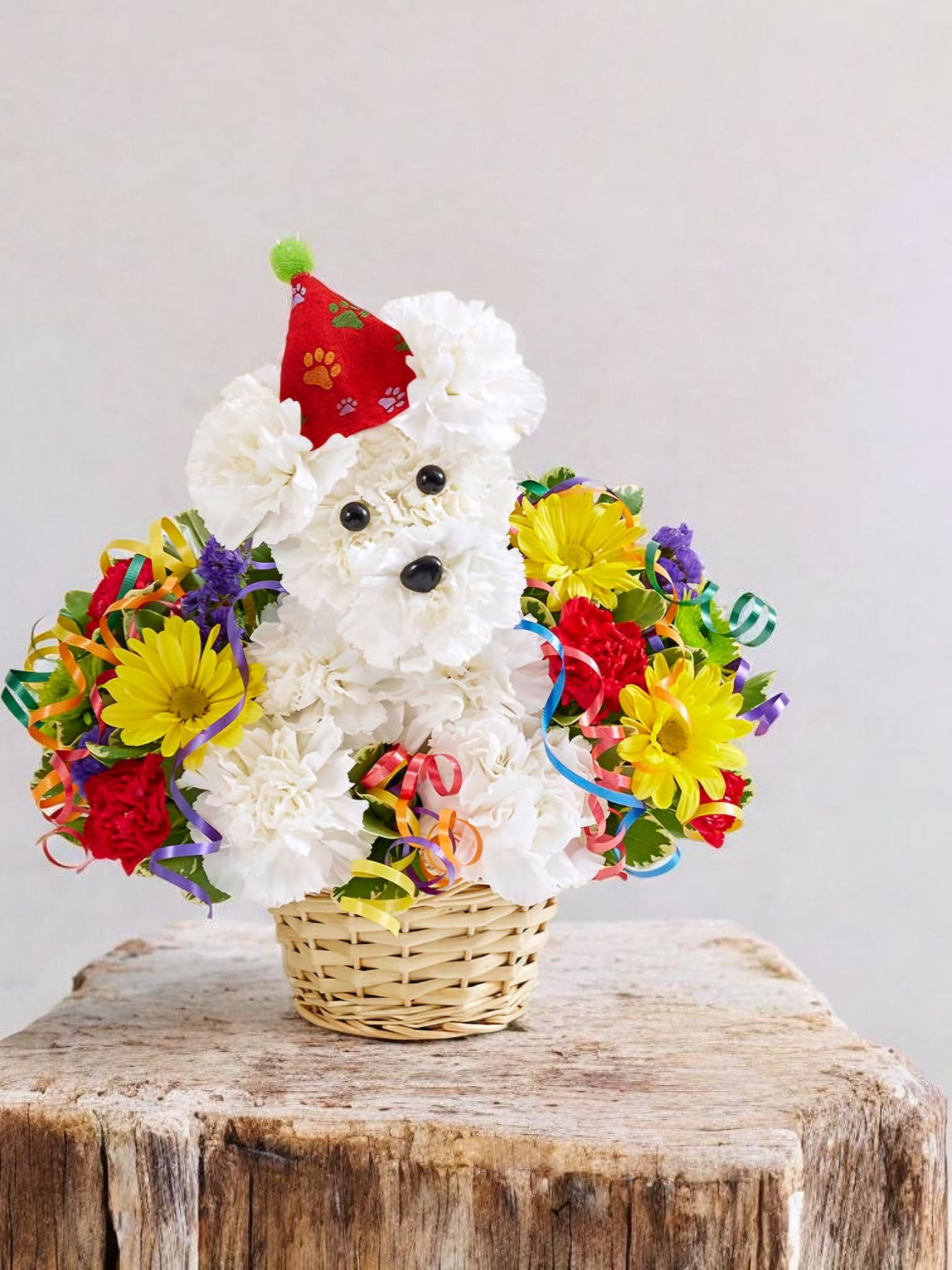 White flower teddy bear in a basket with colorful ribbon accents