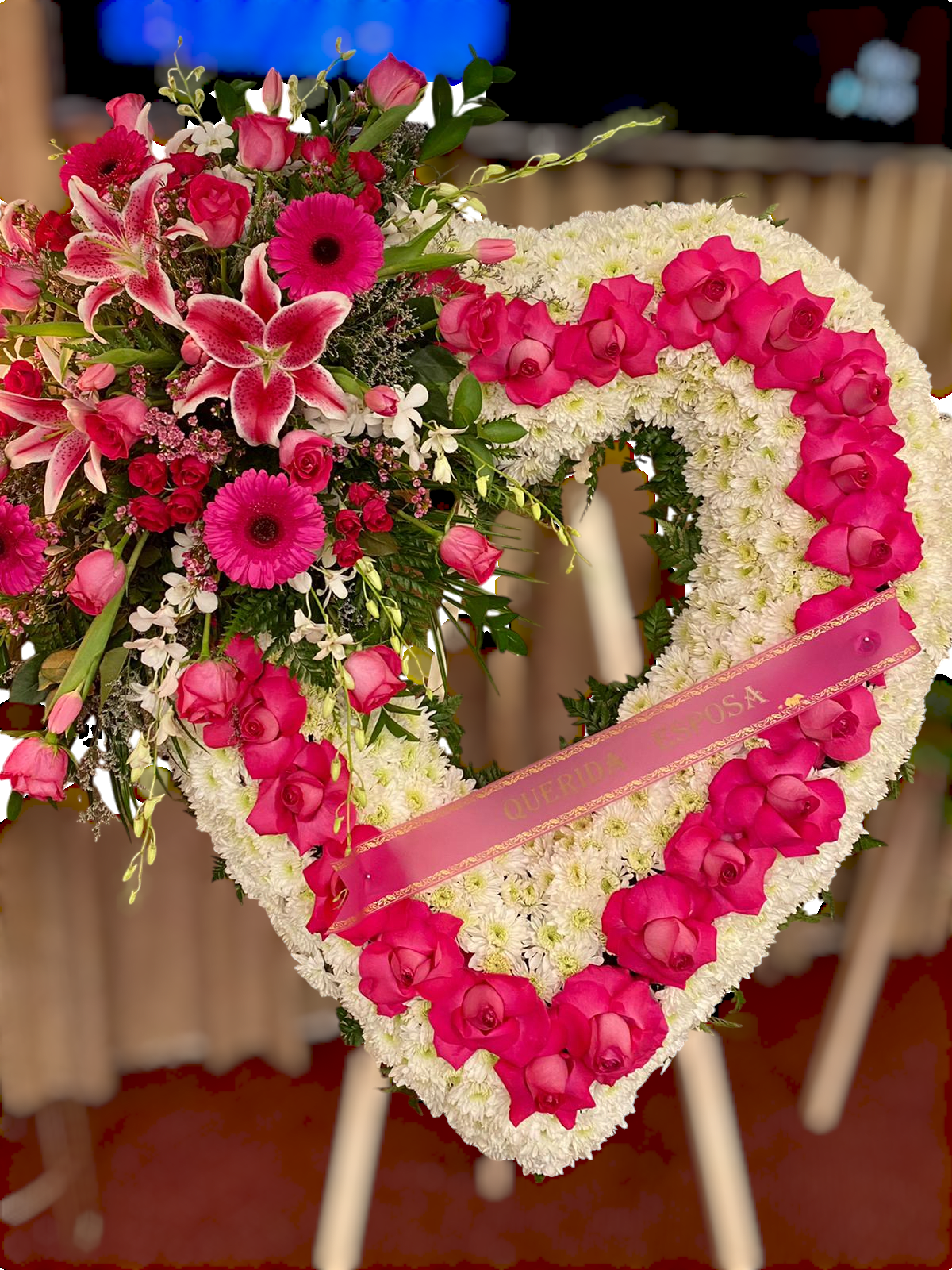 Heartfelt Tribute Floral Heart -    A beautiful heart-shaped arrangement adorned with white chrysanthemums, accented by vibrant pink roses, gerberas, lilies, and orchids. Designed to express deep love and remembrance, this floral heart is a touching tribute for honoring the memory of a cherished loved one.  