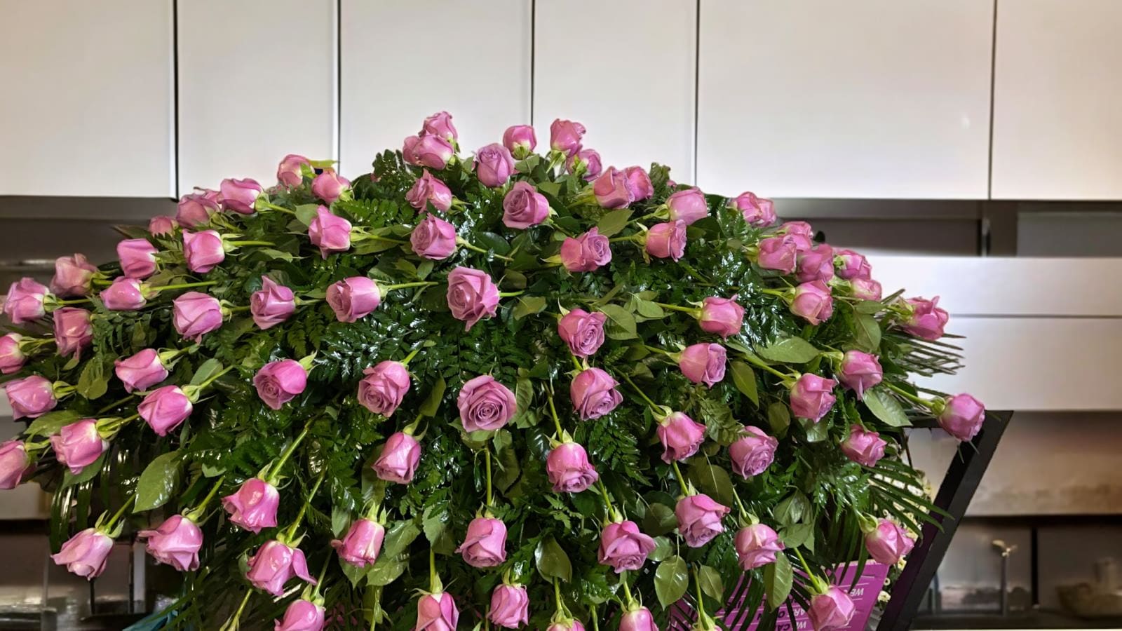 Large arrangement of pink roses over dense greenery