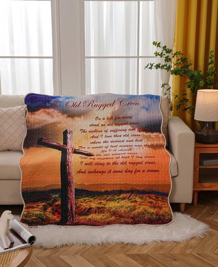A printed blanket with a cross and religious text draped over a sofa