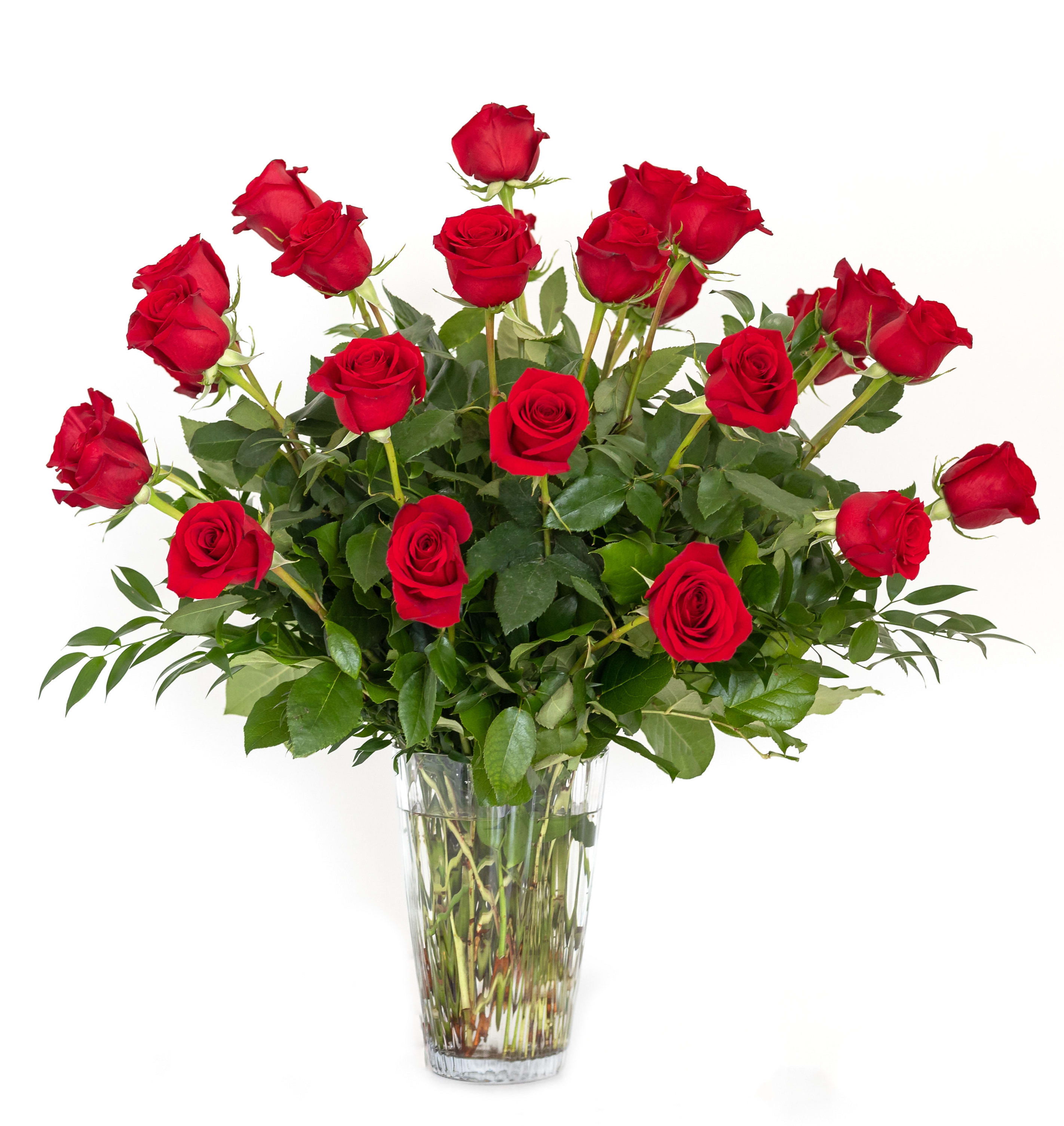 Red roses arranged in a clear glass vase
