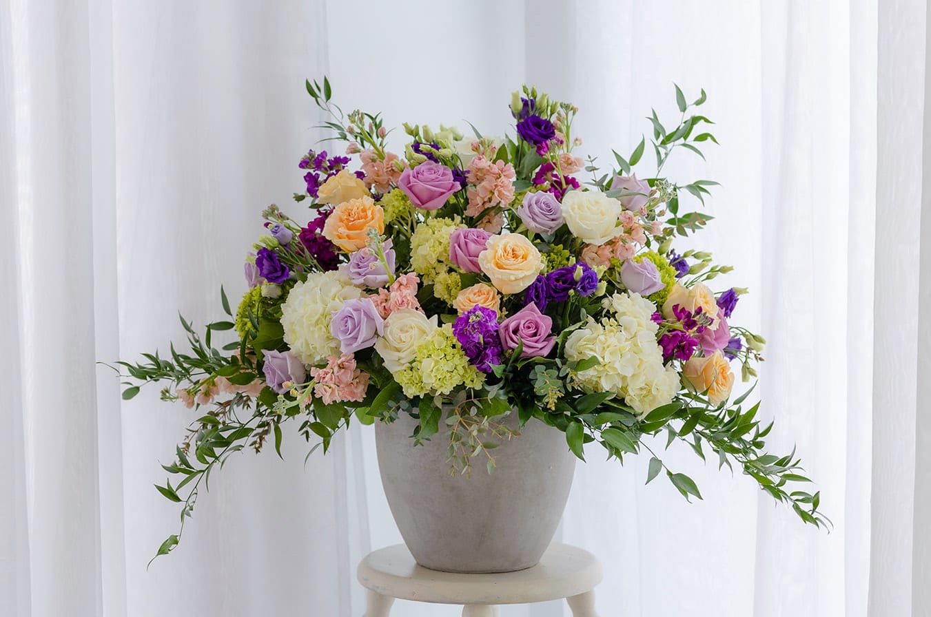 Mixed pastel roses and hydrangeas in a gray vase