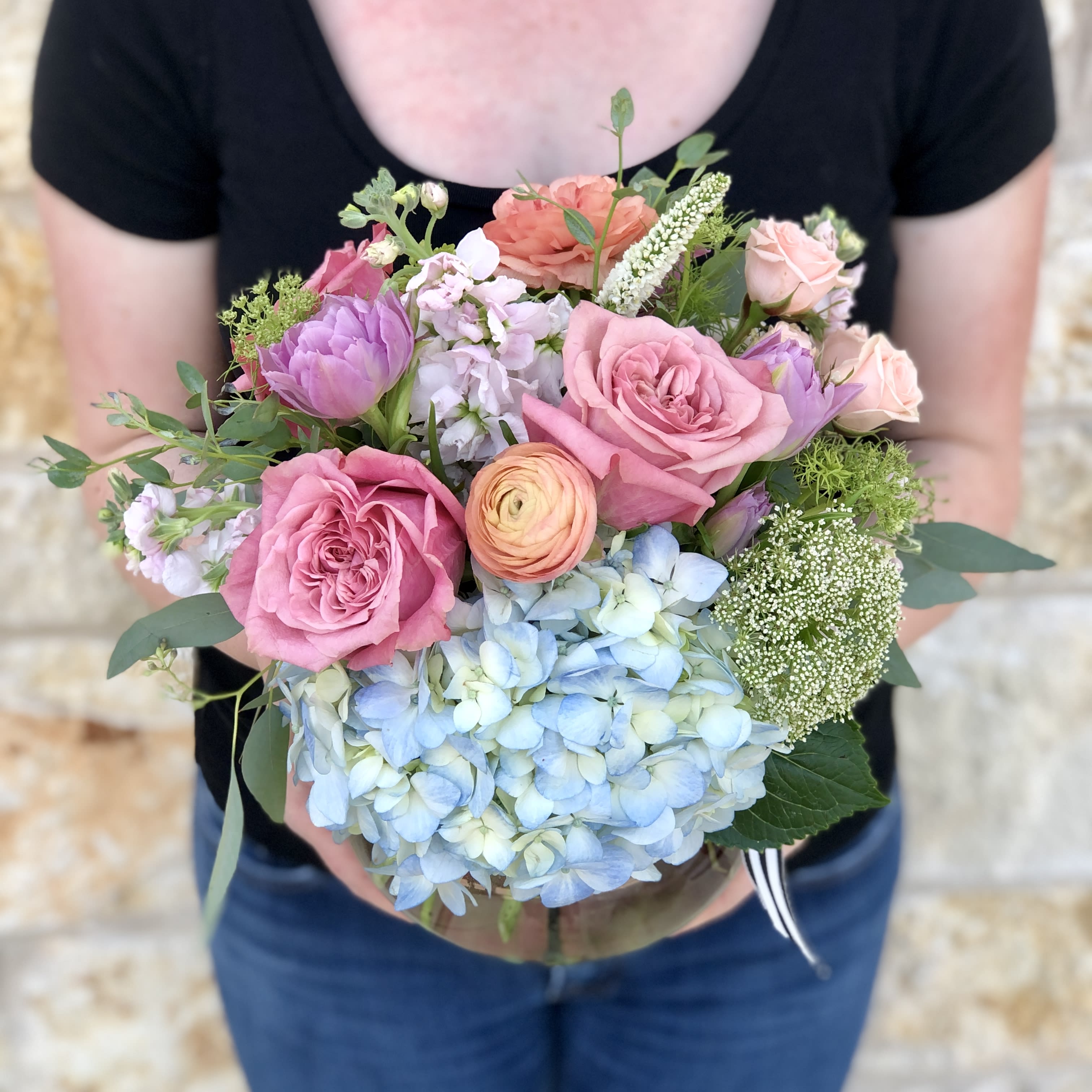 Seasonal Soft Garden - A soft and delicate English garden style arrangement in shades of cream, pink/peach, and lavender/soft blues.  Overall design is approx. 11" x 11" and is delivered in a clear glass vase. Floral varieties may vary but will be of similar quality and style.  