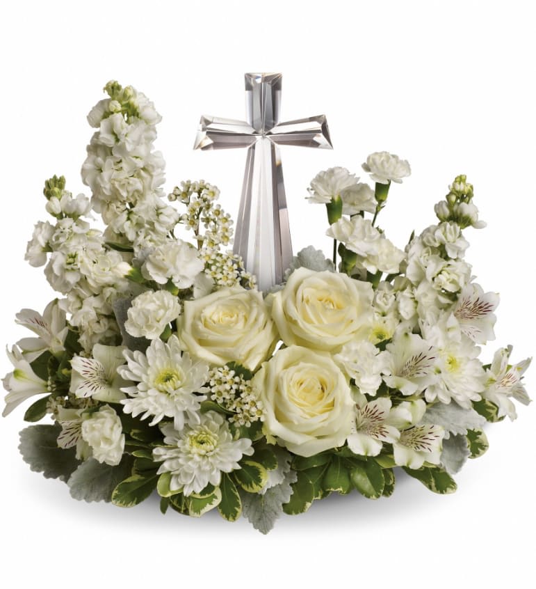 Divine Peace Bouquet - An elegant display of faith and divine peace, this beautiful arrangement will comfort the bereaved in a truly thoughtful and respectful way. An exquisite crystal cross is surrounded by a bed of lovely blossoms. It is sure to be appreciated and always remembered. A fragrant mix of pure white blooms - including roses, alstroemeria, stock, carnations and waxflower - is accented with dusty miller and variegated pittosporum around an exclusive Crystal Cross keepsake. Approximately 16 1/2" W x 13 1/2" H