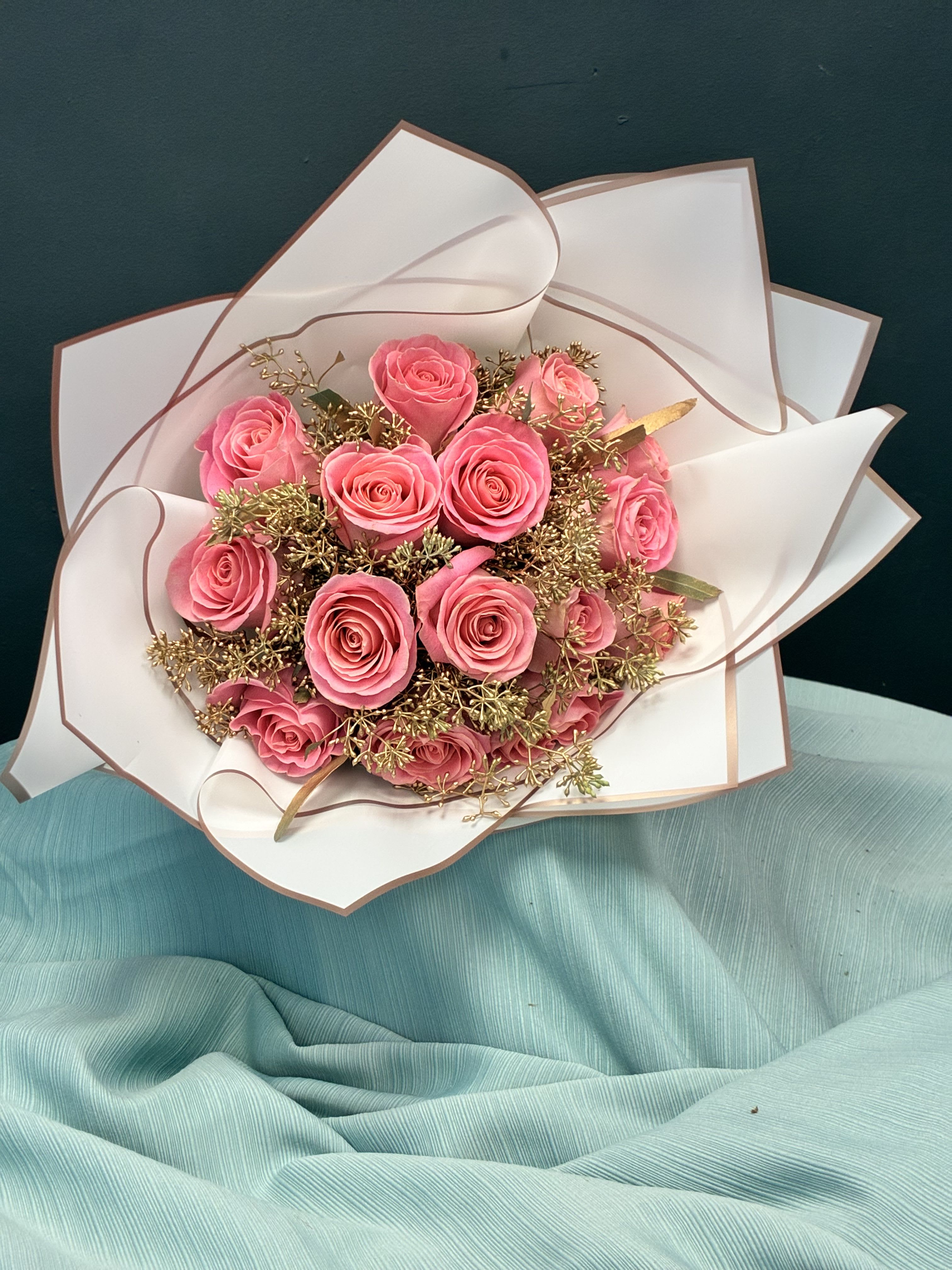 Bouquet of pink roses wrapped in white paper