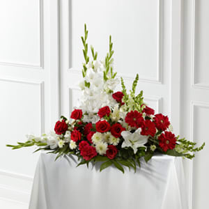 Red and white floral arrangement on a draped table