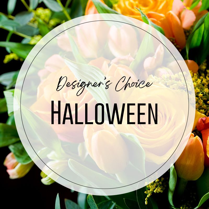 Orange tulips and roses with green foliage behind a Halloween label