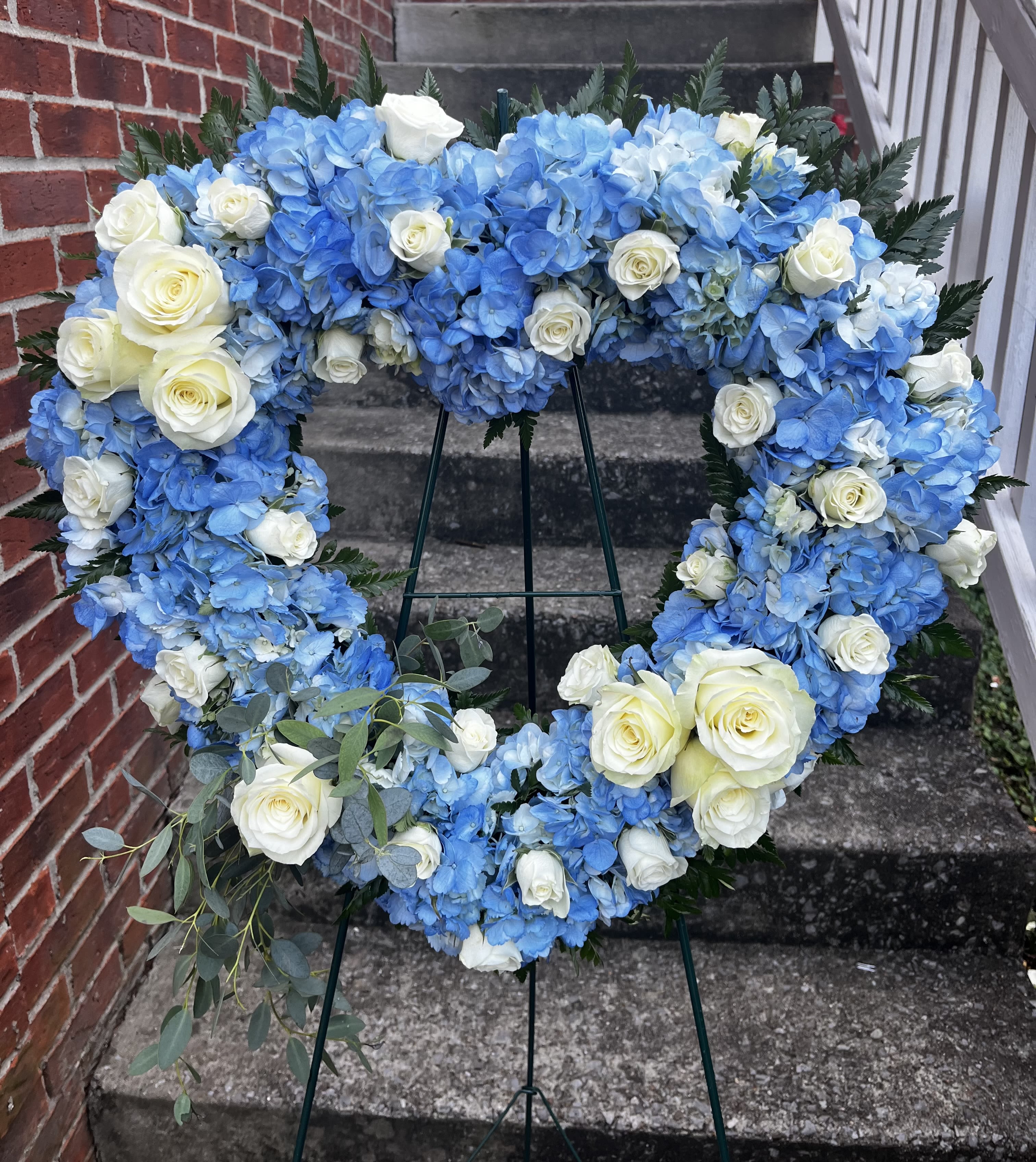 Heavenly Heart - This beautiful heart is made with white roses, white spray, roses, and blue hydrangea with beautiful greenery.