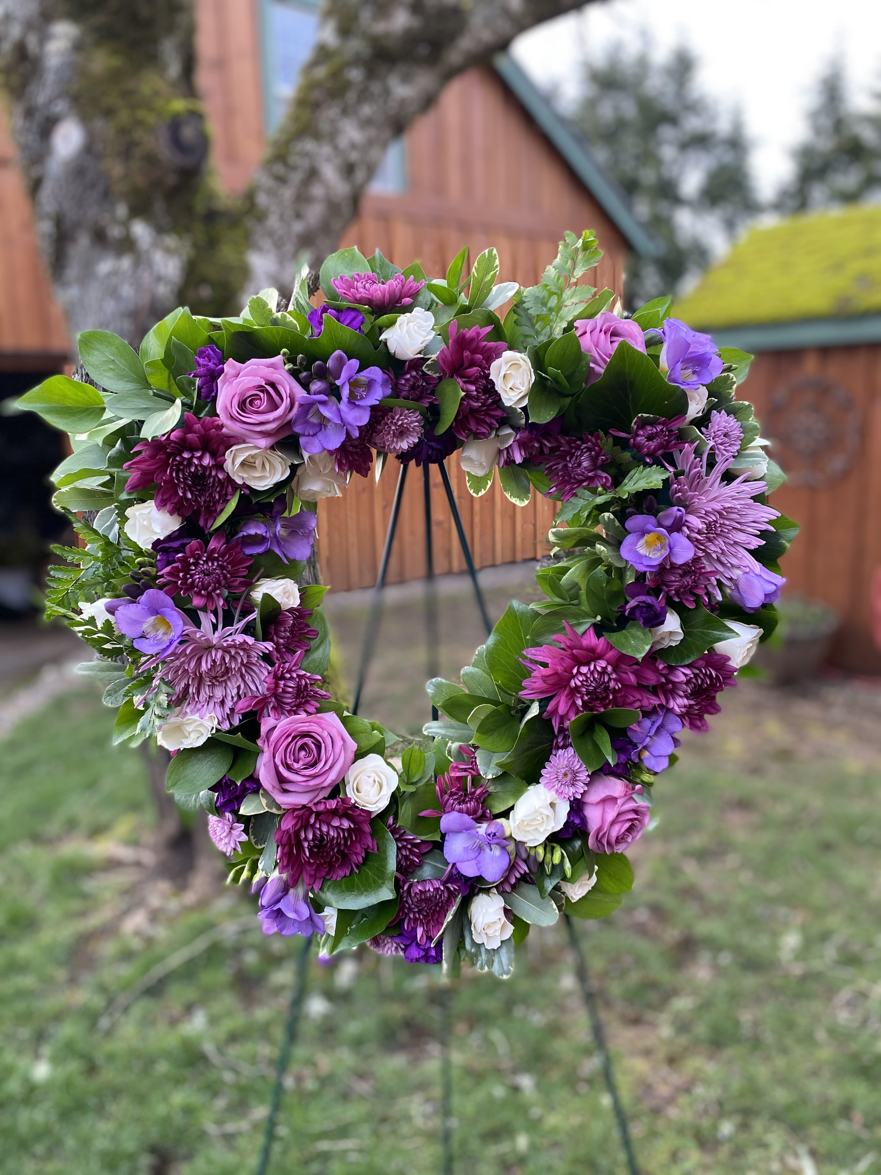 Heart-shaped floral wreath with purple and white blooms