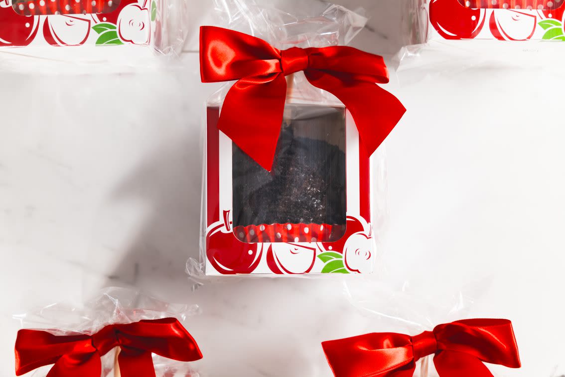 Wrapped gift box with a red bow and a dark treat inside