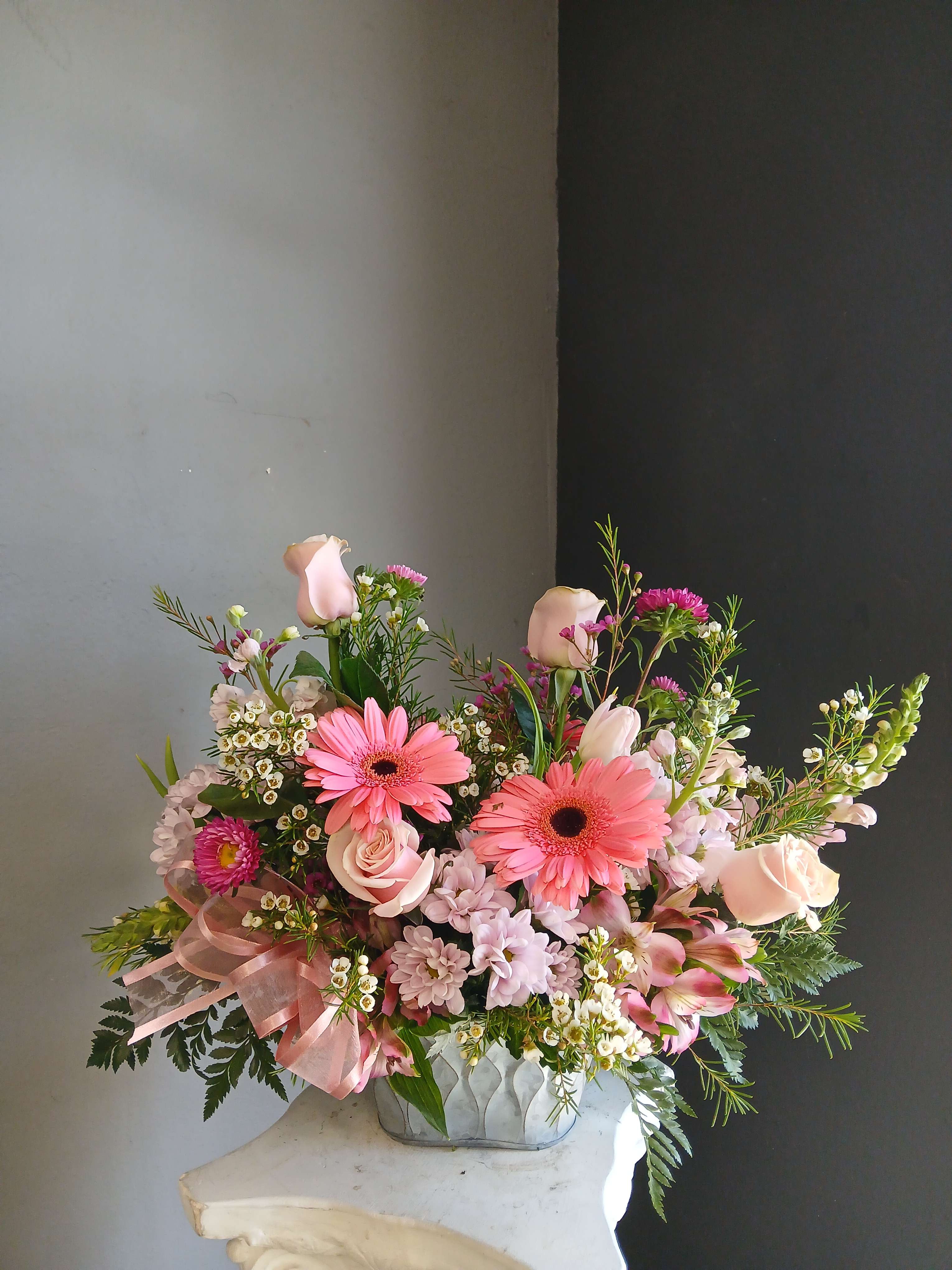 Pink mixed bouquet in a low vase with gerbera daisies and roses