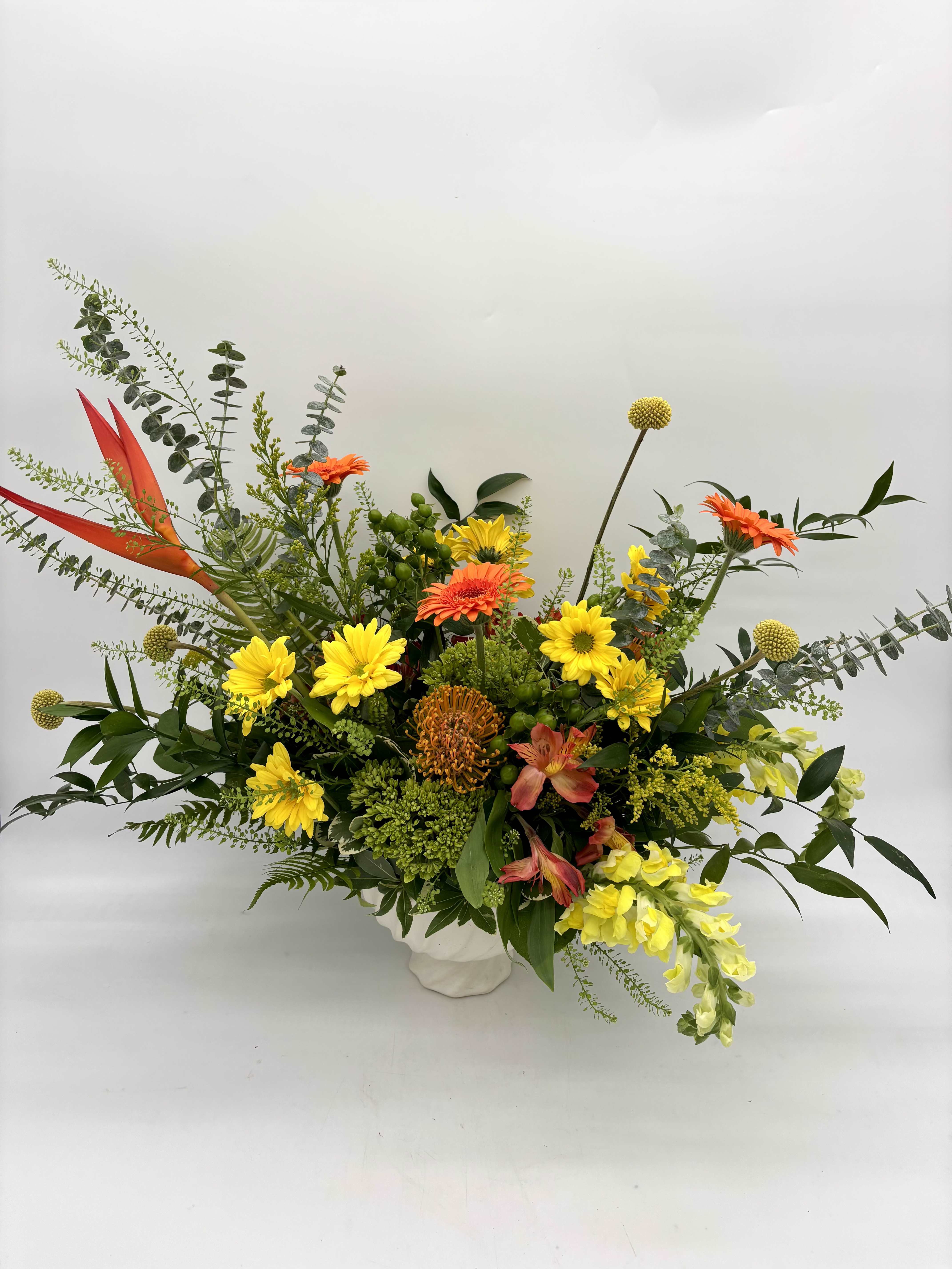 Citrus Zest Centerpiece - Citrus Zest Centerpiece is lively and bursting with sunny yellows, vibrant oranges, and lush greenery. Arranged with playful texture and natural movement in a modern ceramic compote, this cheerful design that brings warmth and color to any table or celebration.