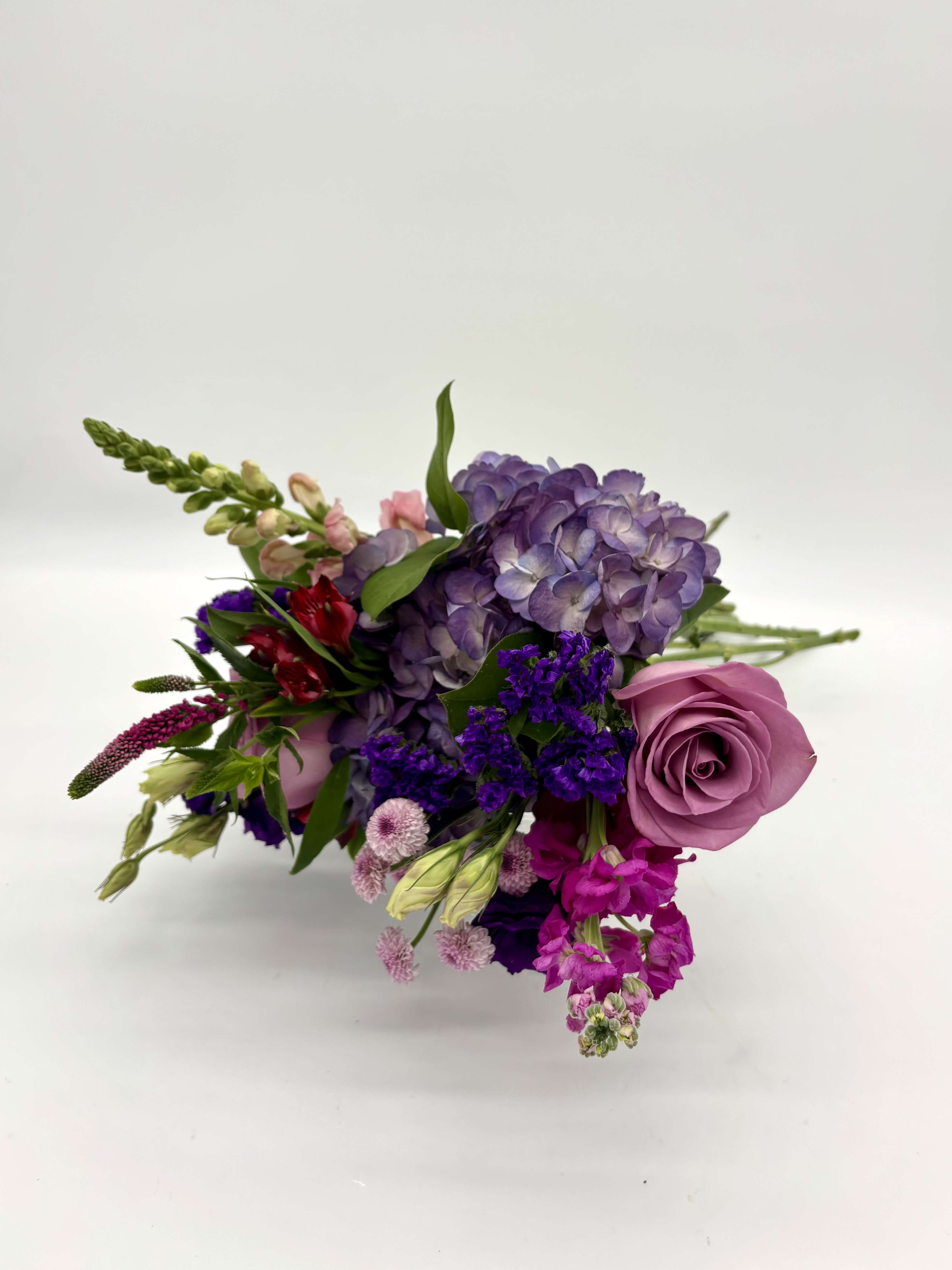 Cherry Berry Wrapped Bouquet - Inspired by the colors of freshly picked berries, Cherry Berry features a striking mix of pink, red, and purple blooms. This wrapped bouquet is full of jewel toned blooms that will make for a 'berry' sweet addition to the recipient's day!