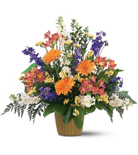 Mixed bouquet in a ribbed basket with orange, purple, white, and yellow flowers