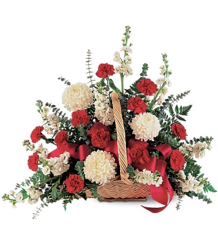 Basket arrangement of red and white carnations with a red ribbon